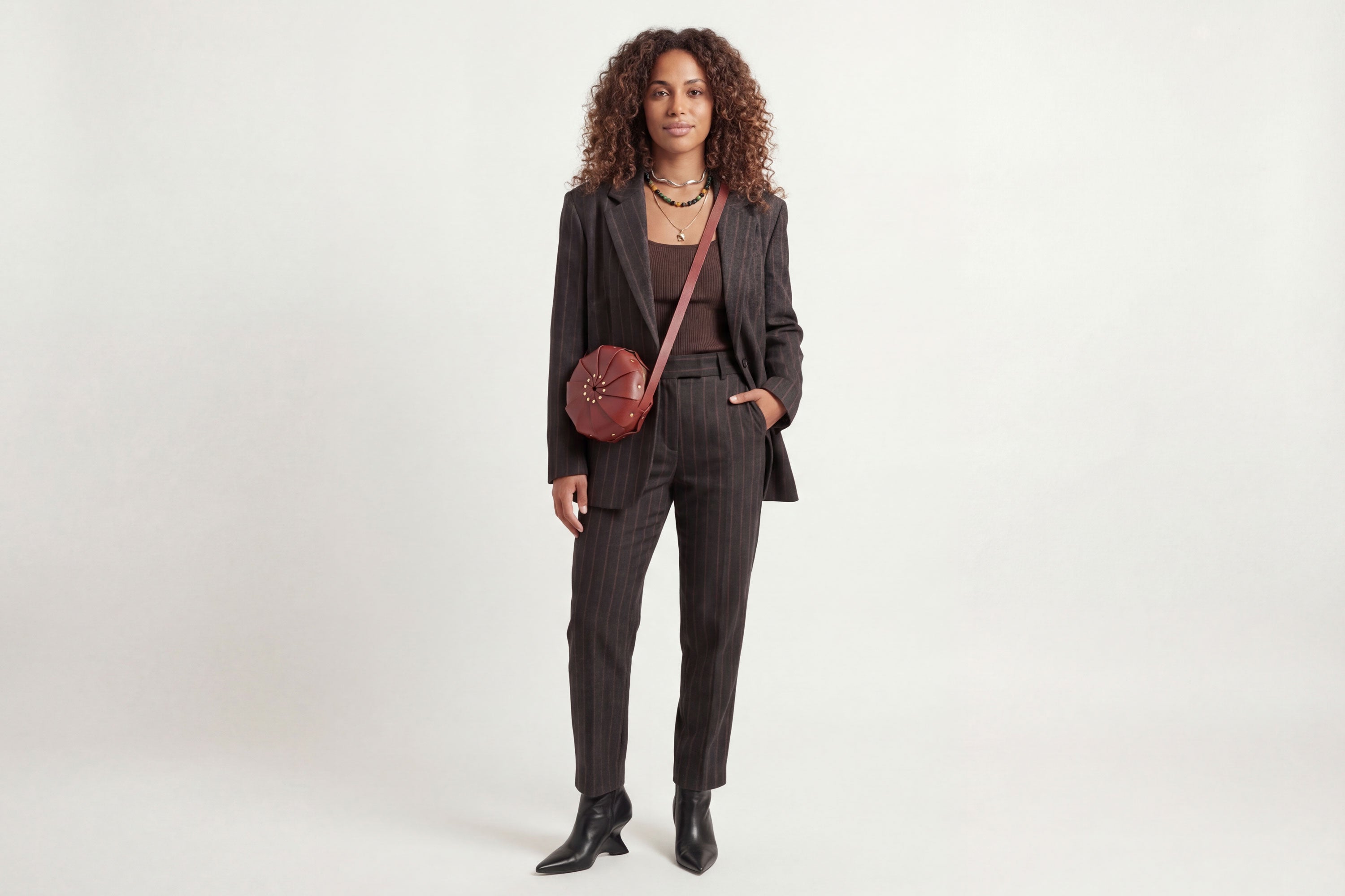 Anemo Leather Bag Red Color On A Woman Model Floral Design Premium Minimalist Modern Circle Round Pouch Crossbody Atelier Madre Manuel Dreesmann Barcelona Spain