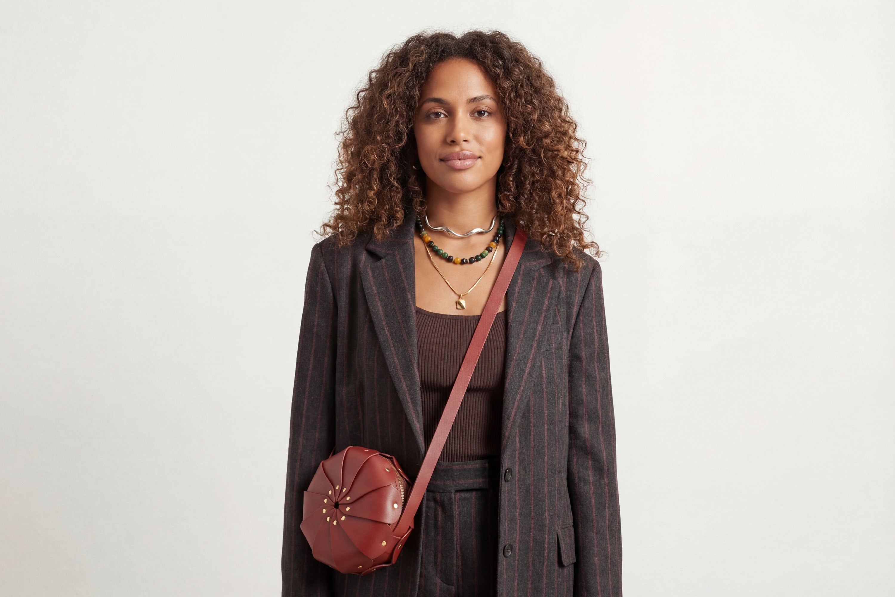 Anemo Leather Bag Red Color On A Woman Model Floral Design Premium Minimalist Modern Circle Round Pouch Crossbody Atelier Madre Manuel Dreesmann Barcelona Spain