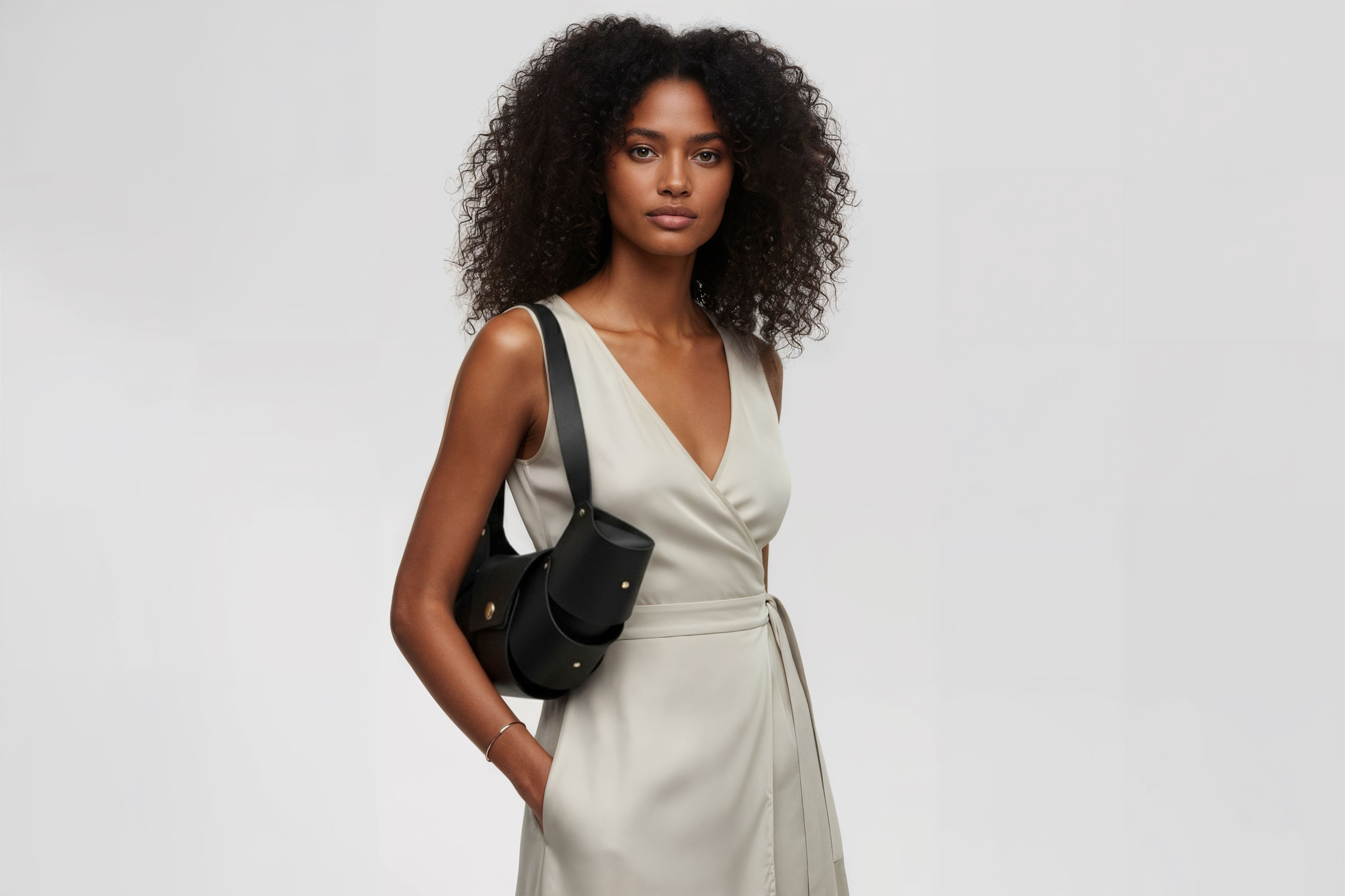 Croissant Bag Big Black Leather Magnetic Closure On A Woman Model Full Grain Vegetable Tanned Leather High Quality Modern Minimalistic Organic Design Full Brass Rivets Atelier Madre Manuel Dreesmann Barcelona Spain