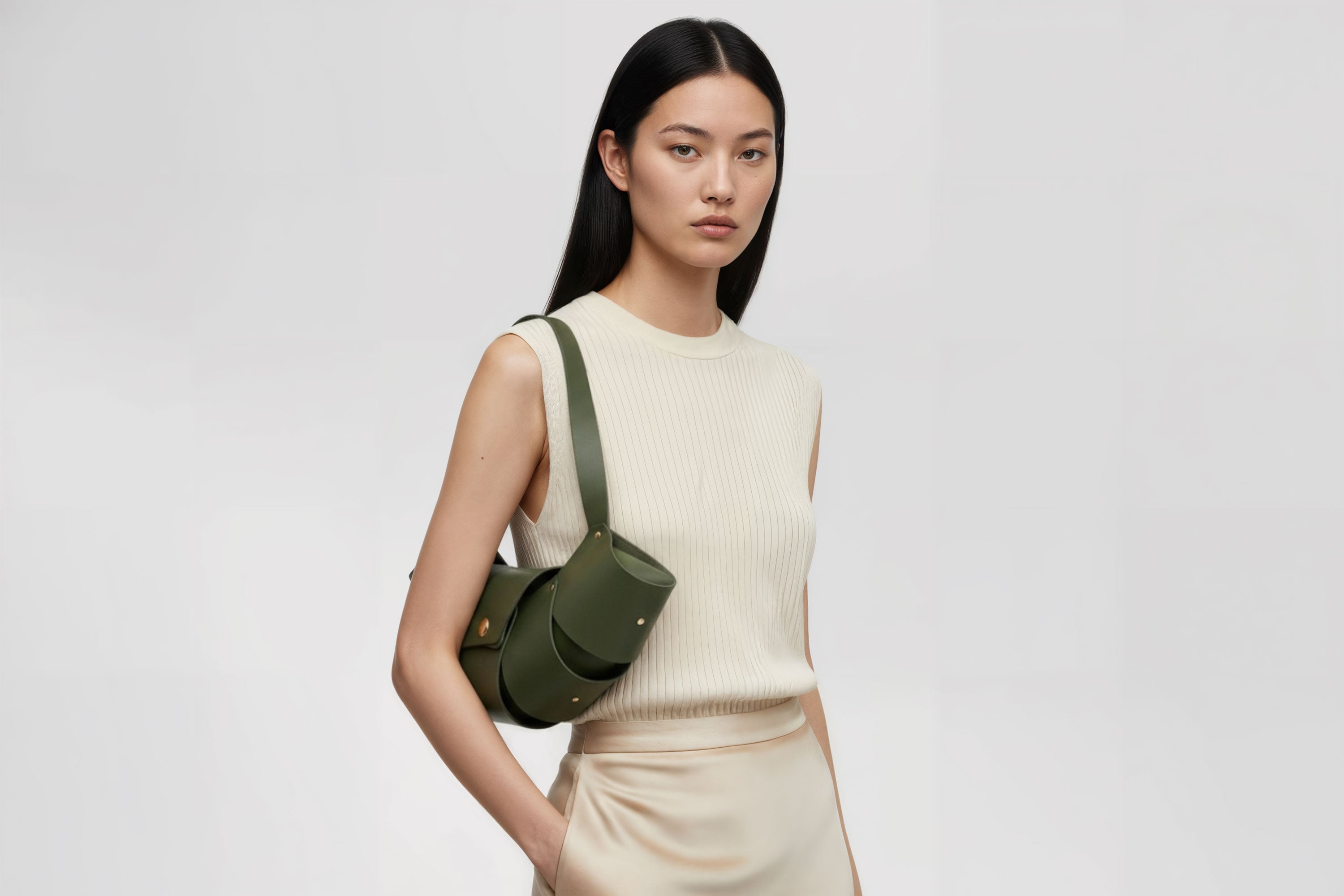 Croissant Bag Big Olive Green Colour Leather Magnetic Closure On A Woman Model Full Grain Vegetable Tanned Leather High Quality Modern Minimalistic Organic Design Full Brass Rivets Atelier Madre Manuel Dreesmann Barcelona Spain