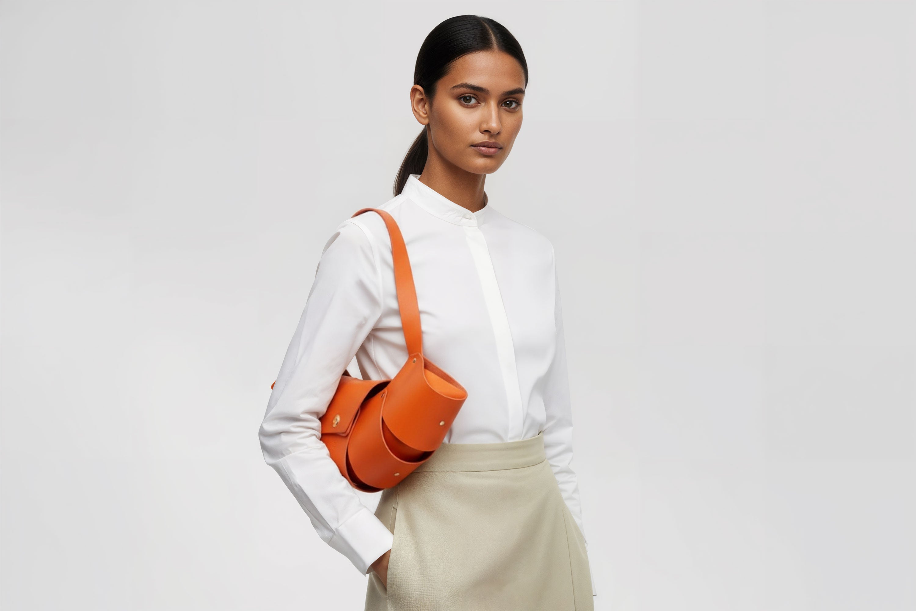 Croissant Bag Big Orange Colour Leather Magnetic Closure On A Woman Model Full Grain Vegetable Tanned Leather High Quality Modern Minimalistic Organic Design Full Brass Rivets Atelier Madre Manuel Dreesmann Barcelona Spain