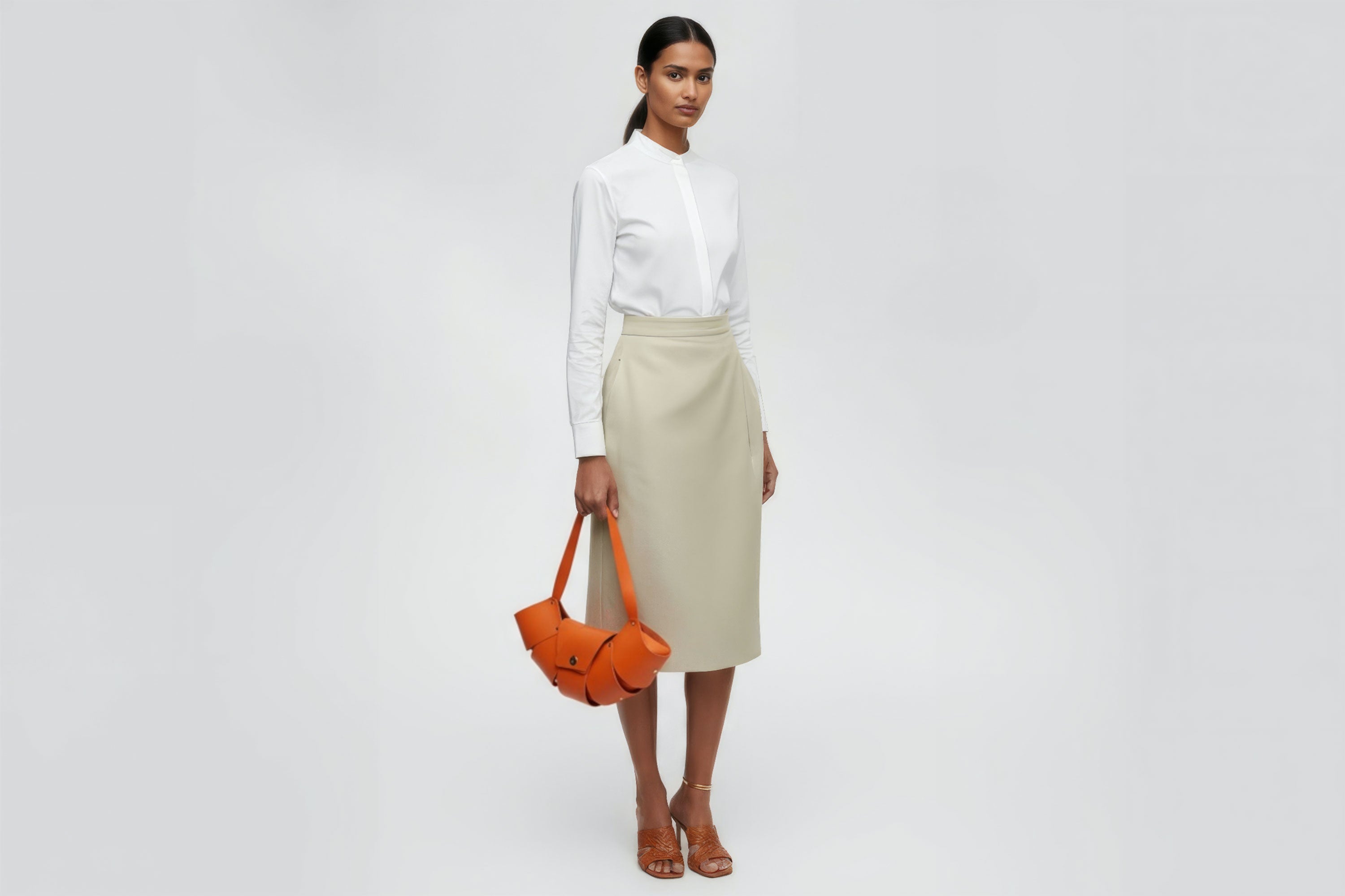 Croissant Bag Big Orange Colour Leather Magnetic Closure On A Woman Model Full Grain Vegetable Tanned Leather High Quality Modern Minimalistic Organic Design Full Brass Rivets Atelier Madre Manuel Dreesmann Barcelona Spain