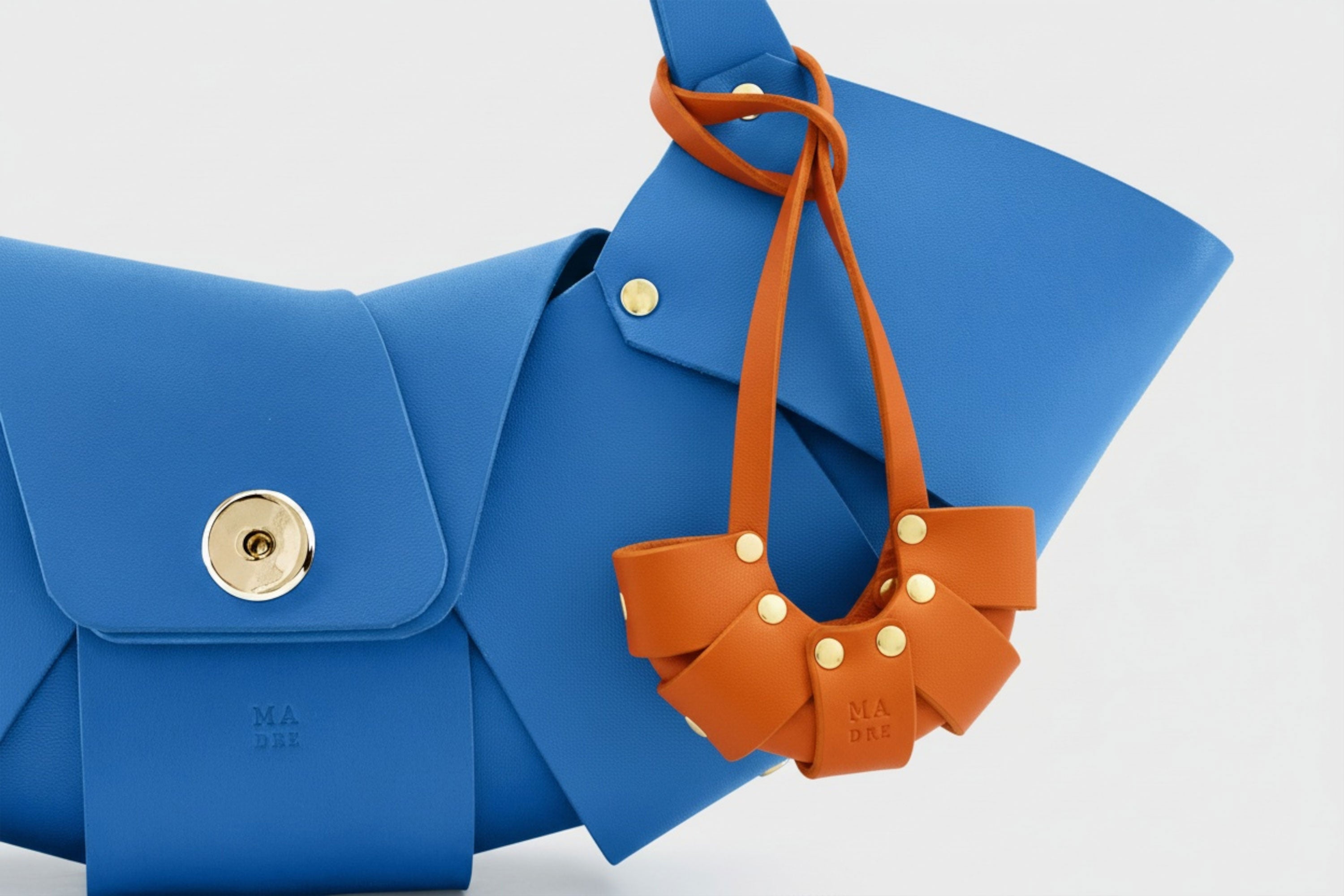 Orange Color Leather Croissant Bag Charm Minimal Premium Design Attached on Royal Blue Croissant Bag Atelier Madre Manuel Dreesmann Barcelona Spain