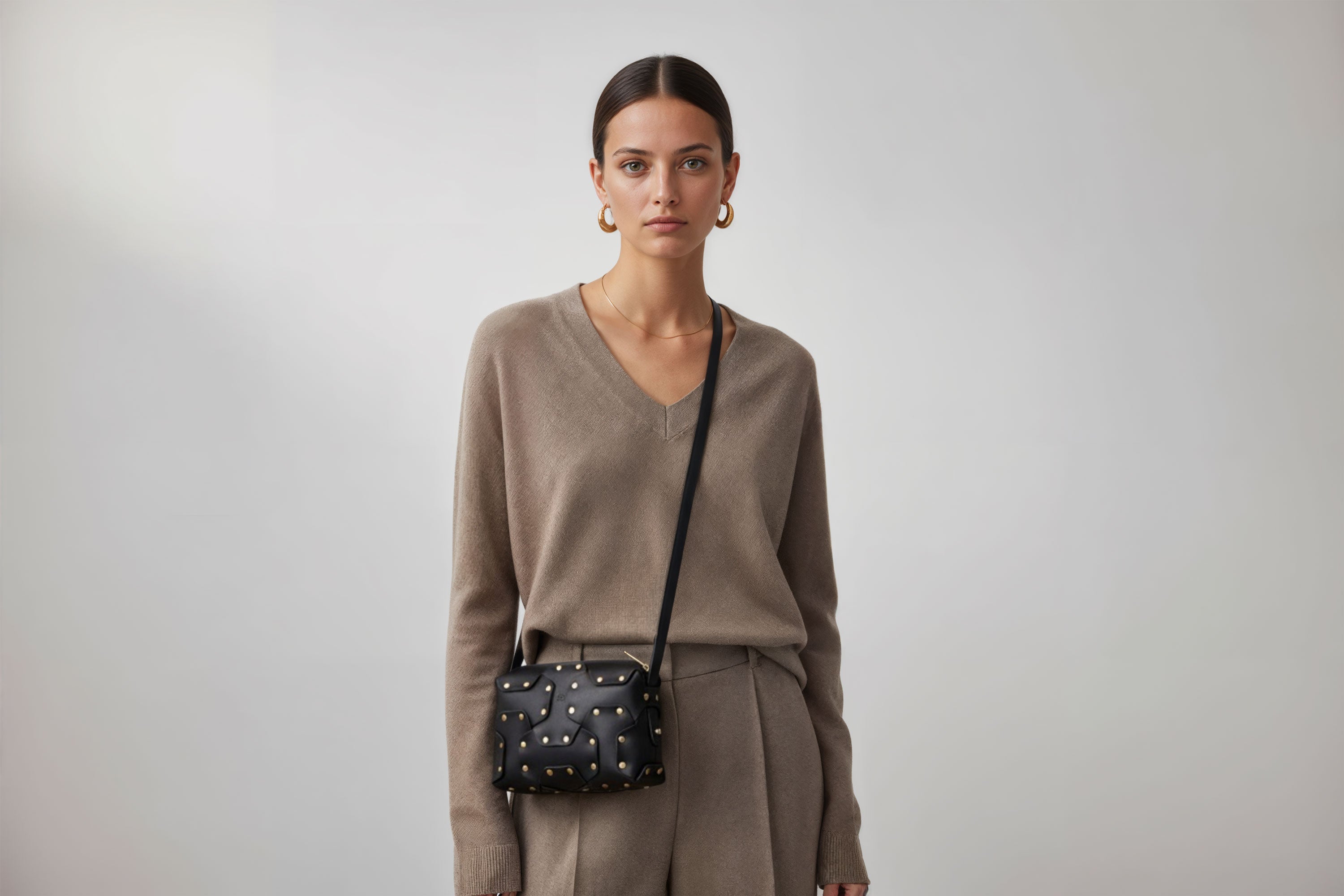 Double Rivet Bag Black Color On A Woman Model Leather Full Grain Vegetable Tanned Leather Modern Minimalist Design Premium Quality Full Brass Clutch Crossbody Shoulder Bag Atelier Madre Manuel Dreesmann Barcelona Spain