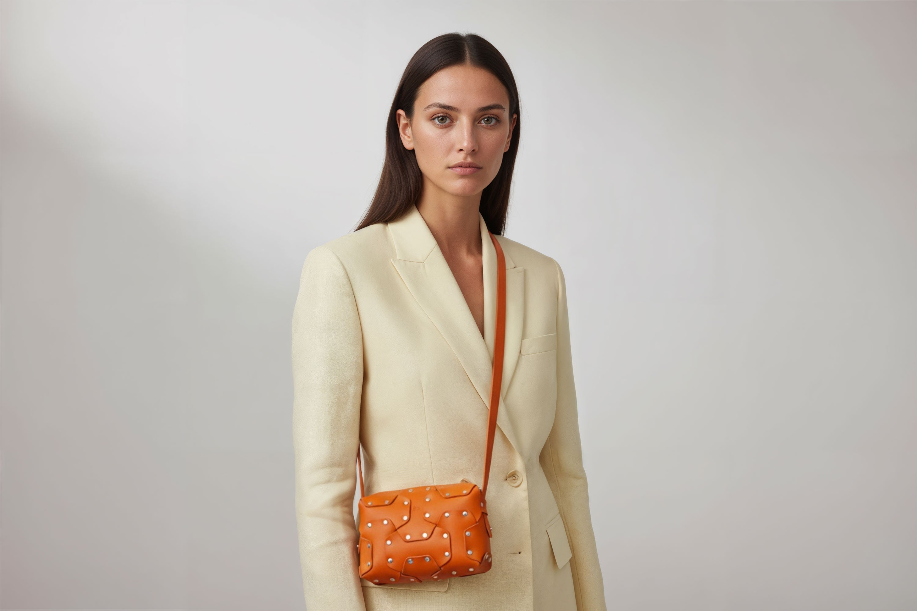 Double Rivet Bag Orange Color On A Woman Model Leather Full Grain Vegetable Tanned Leather Modern Minimalist Design Premium Quality Full Brass Clutch Crossbody Shoulder Bag Atelier Madre Manuel Dreesmann Barcelona Spain