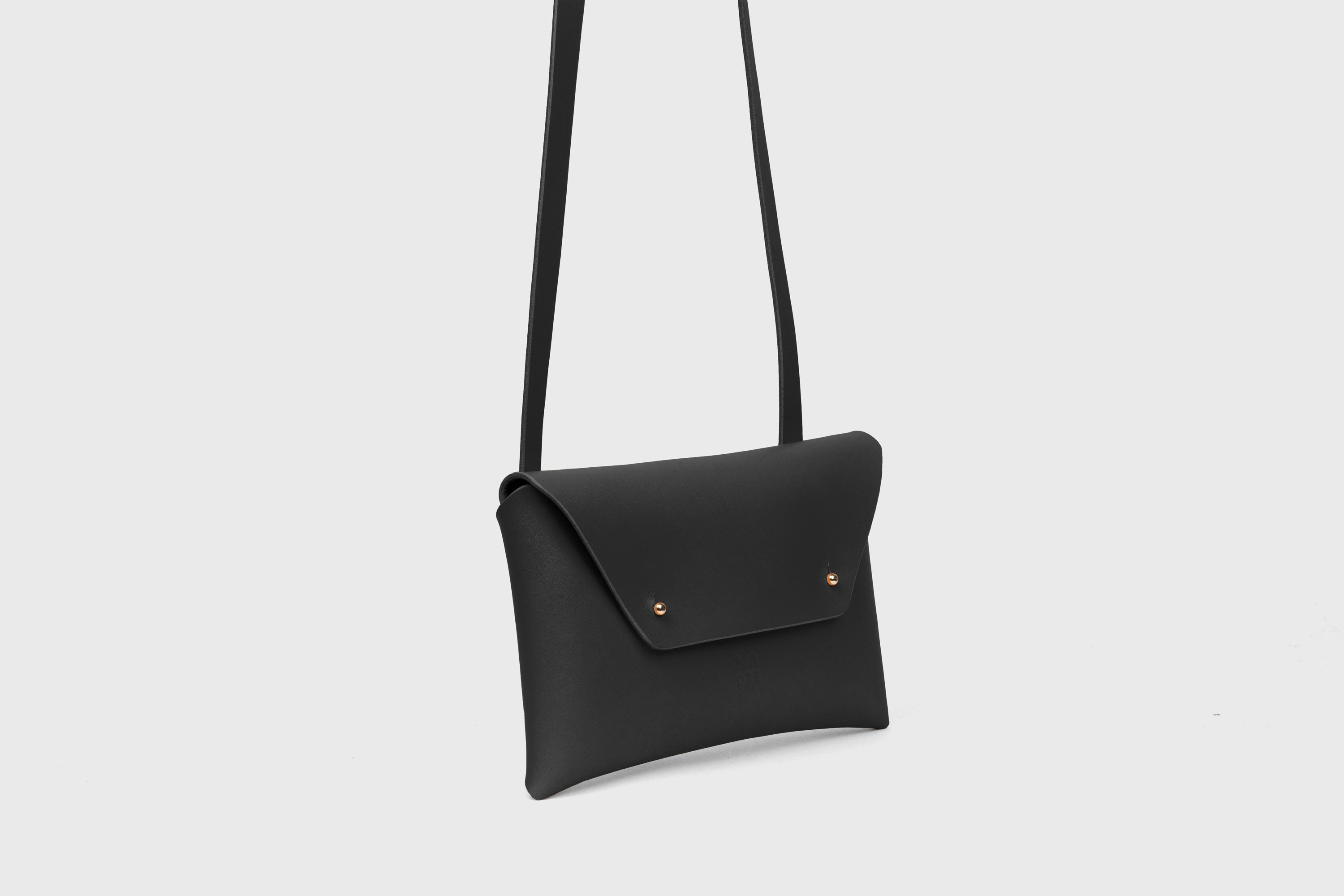 Envelope Bag With a Strap In Black Color Vegetable Tanned Leather Minimalistic Design Atelier Madre Manuel Dreesmann Barcelona Spain