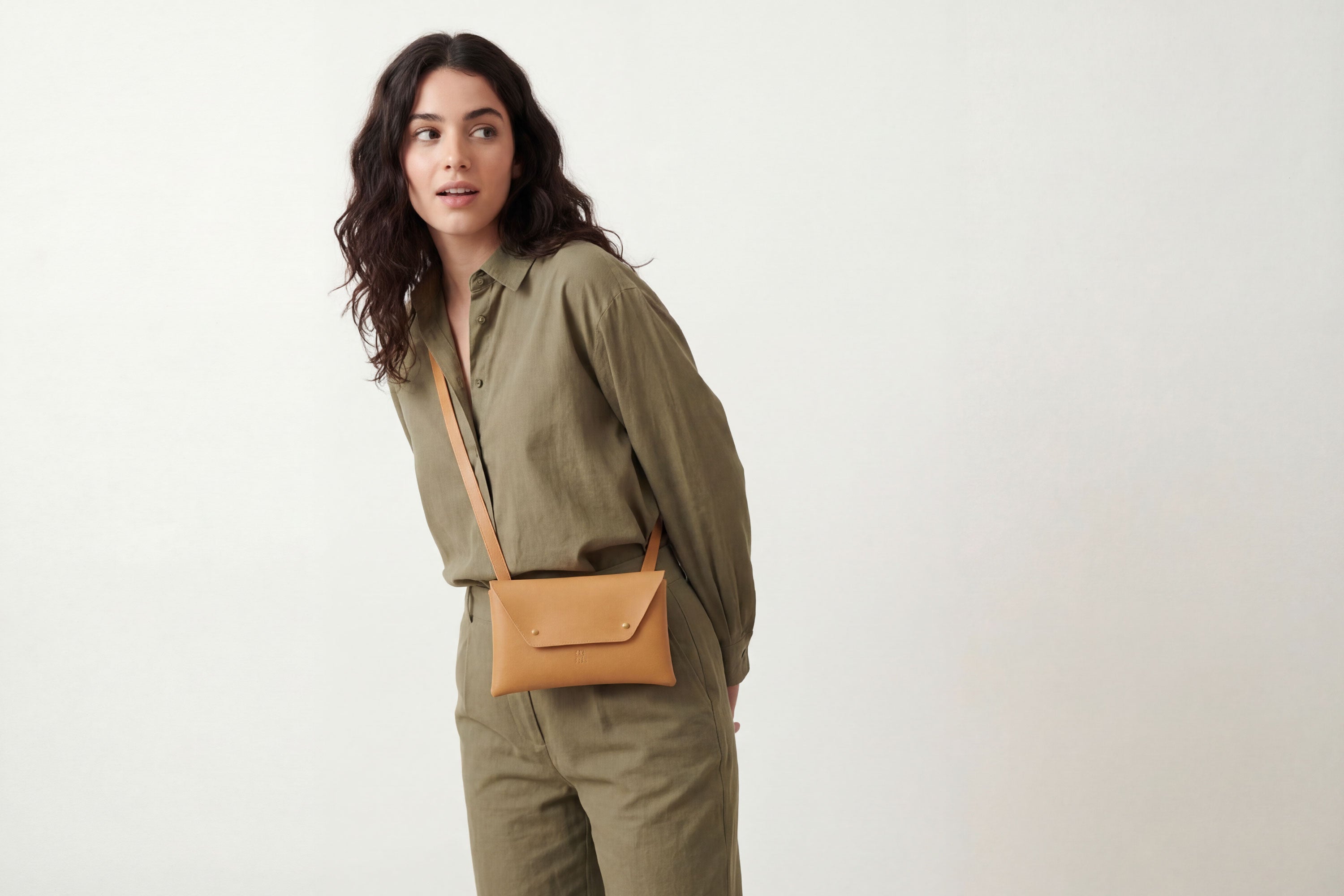 Envelope Bag With a Strap In Brown Color On A Woman Model Vegetable Tanned Leather Minimalistic Design Atelier Madre Manuel Dreesmann Barcelona Spain