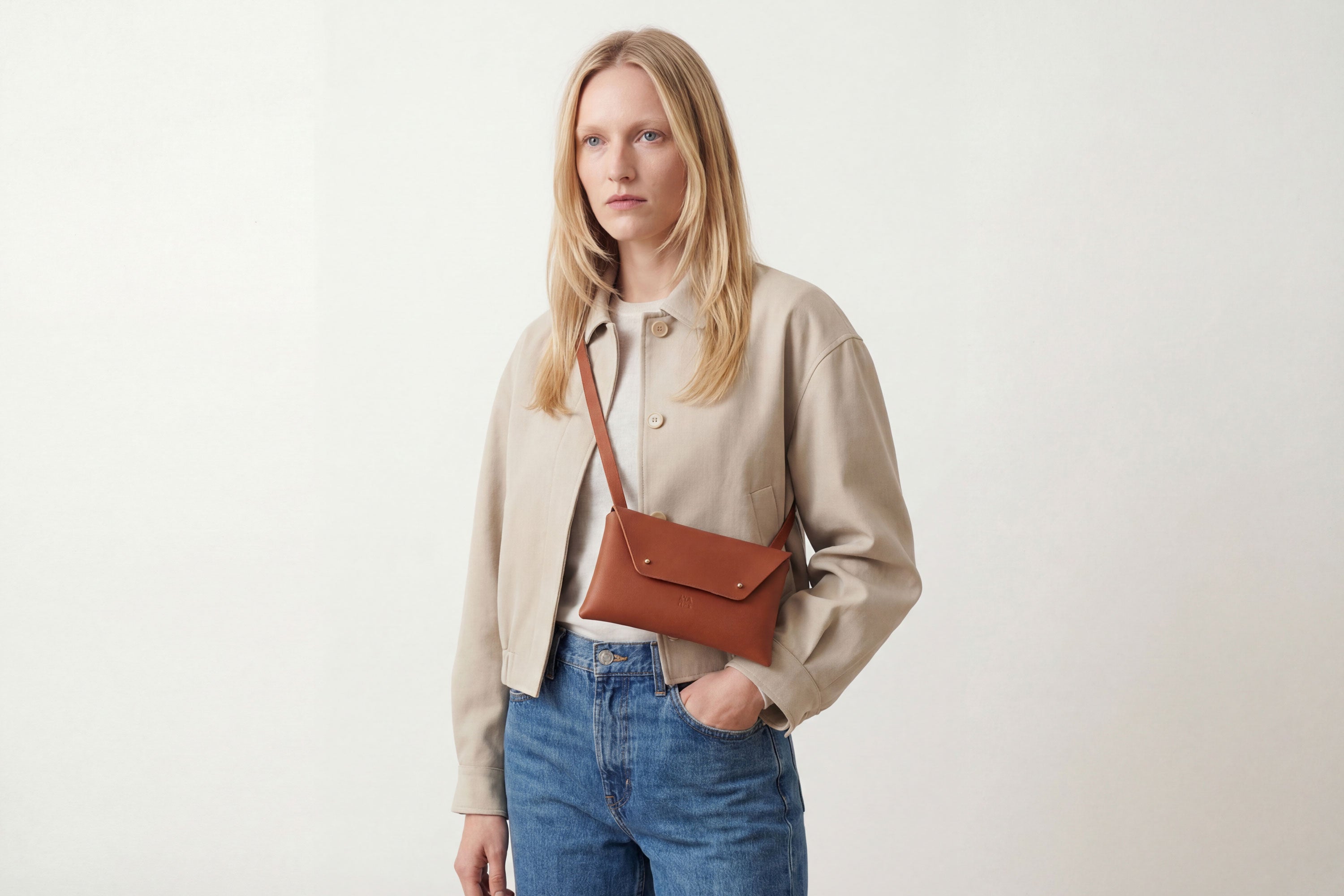Envelope Bag With a Strap In Dark Brown Color On A Woman Model Vegetable Tanned Leather Minimalistic Design Atelier Madre Manuel Dreesmann Barcelona Spain