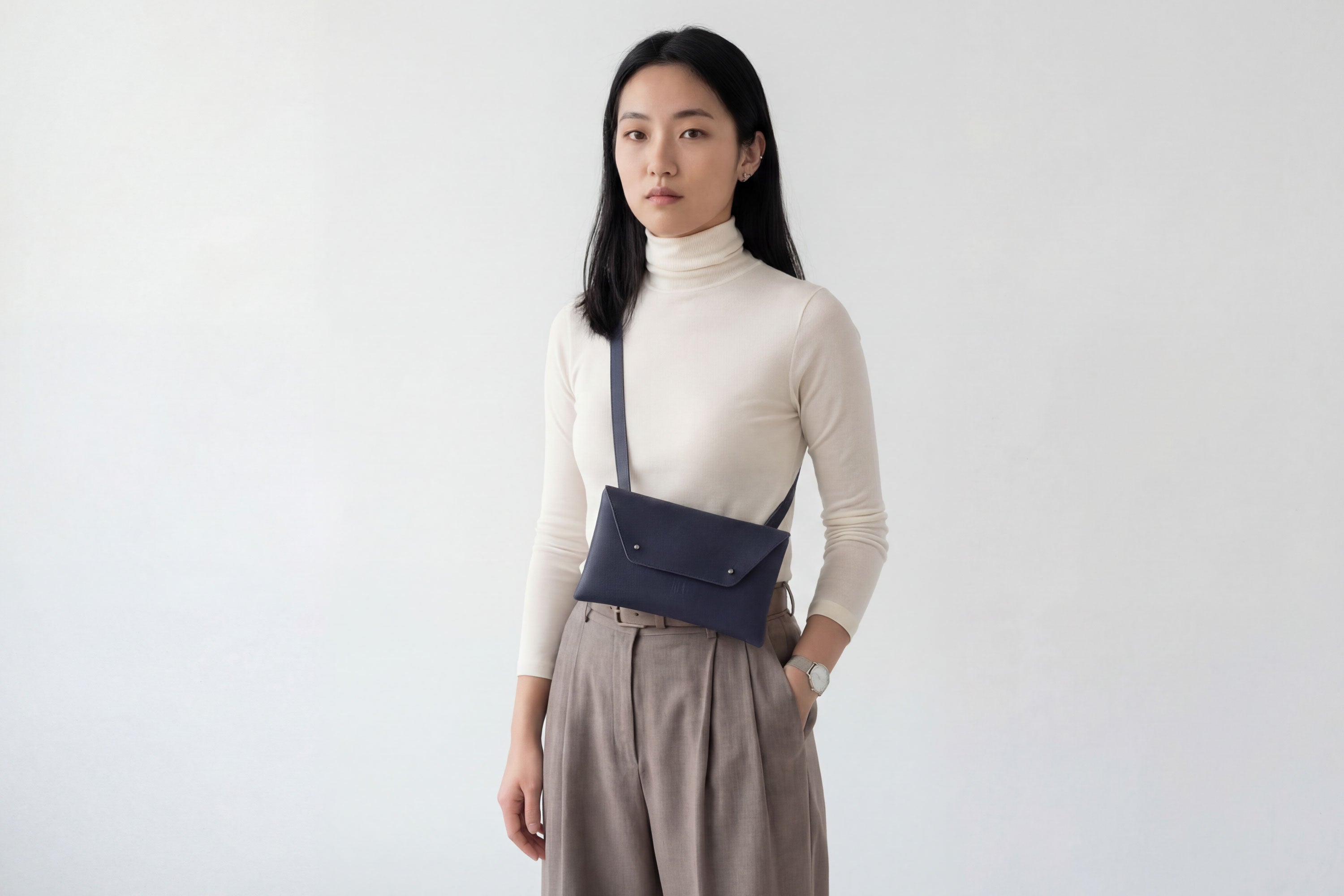 Envelope Bag With a Strap In Marine Blue Color On A Woman Model Vegetable Tanned Leather Minimalistic Design Atelier Madre Manuel Dreesmann Barcelona Spain