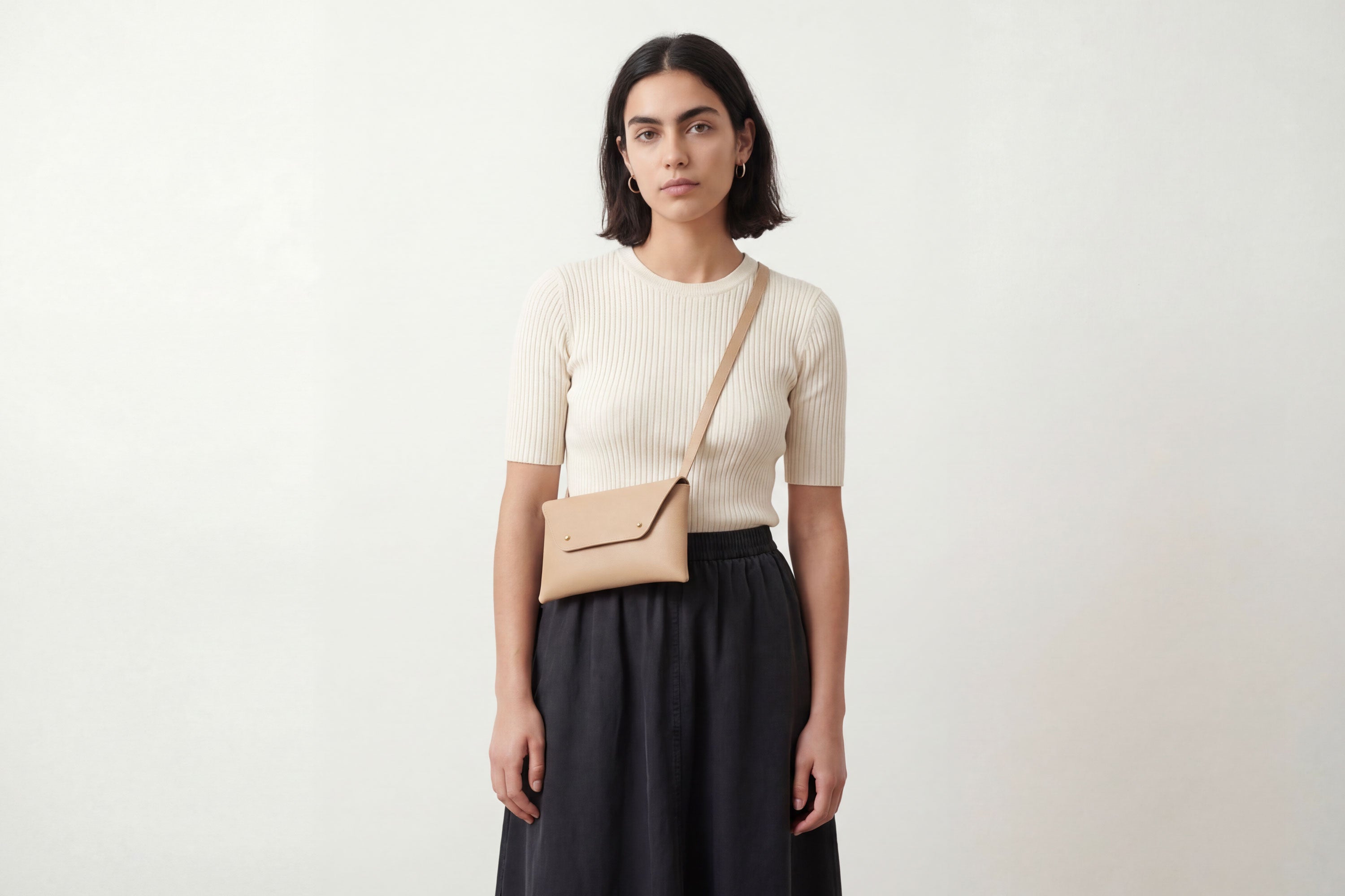 Envelope Bag With a Strap In Natural Color On A Woman Model Vegetable Tanned Leather Minimalistic Design Atelier Madre Manuel Dreesmann Barcelona Spain