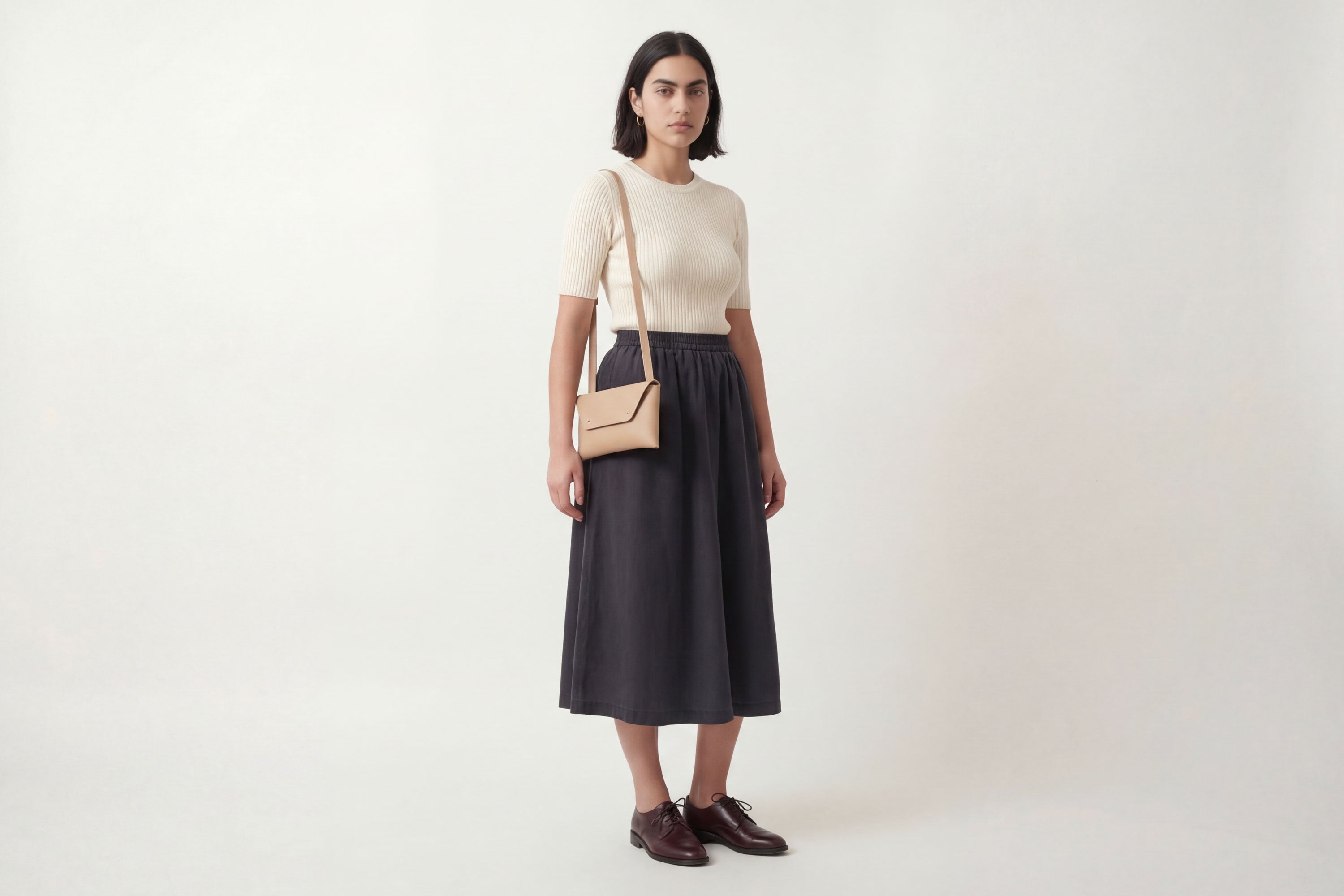 Envelope Bag With a Strap In Natural Color On A Woman Model Vegetable Tanned Leather Minimalistic Design Atelier Madre Manuel Dreesmann Barcelona Spain