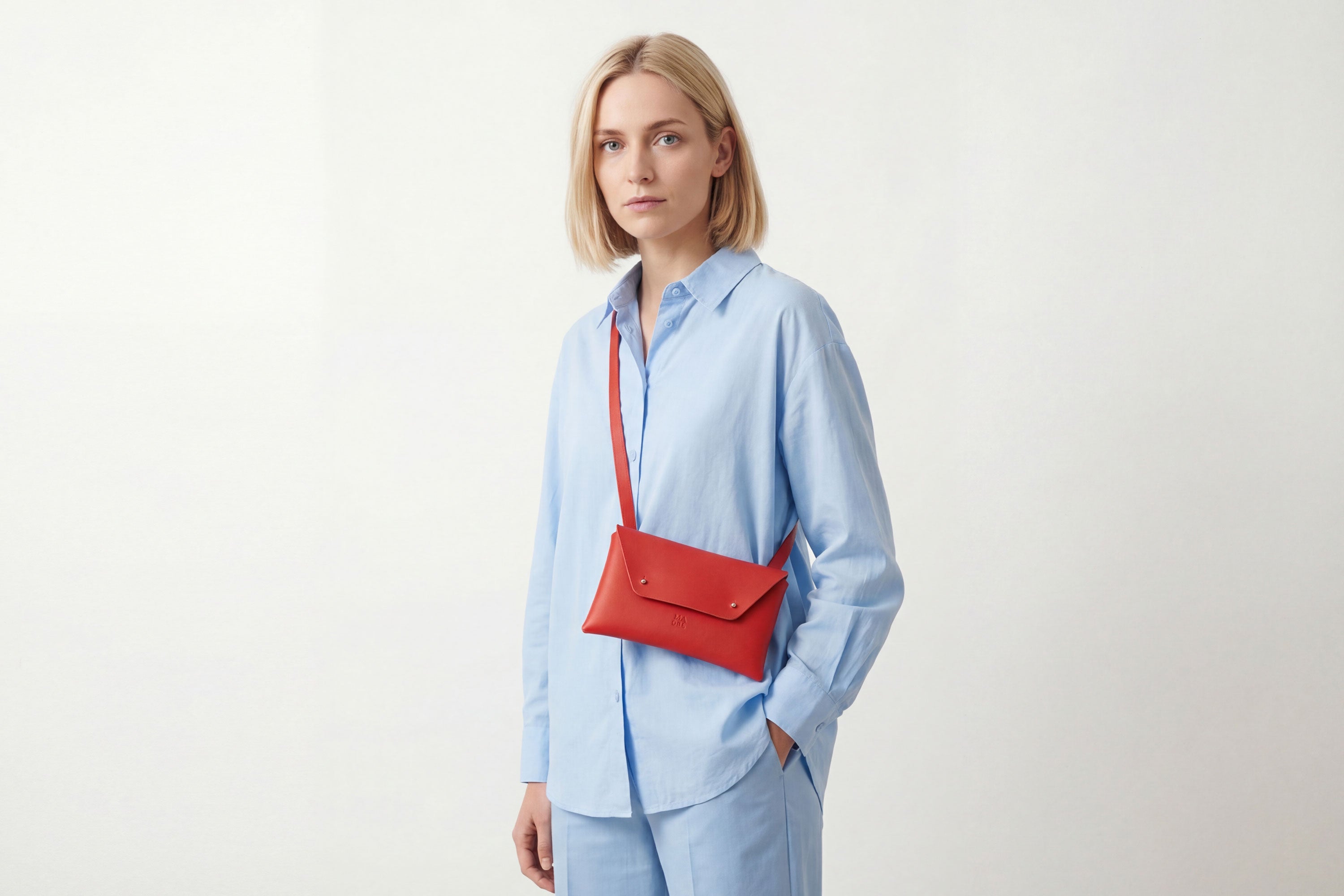 Envelope Bag With a Strap In Red Color On A Woman Model Vegetable Tanned Leather Minimalistic Design Atelier Madre Manuel Dreesmann Barcelona Spain