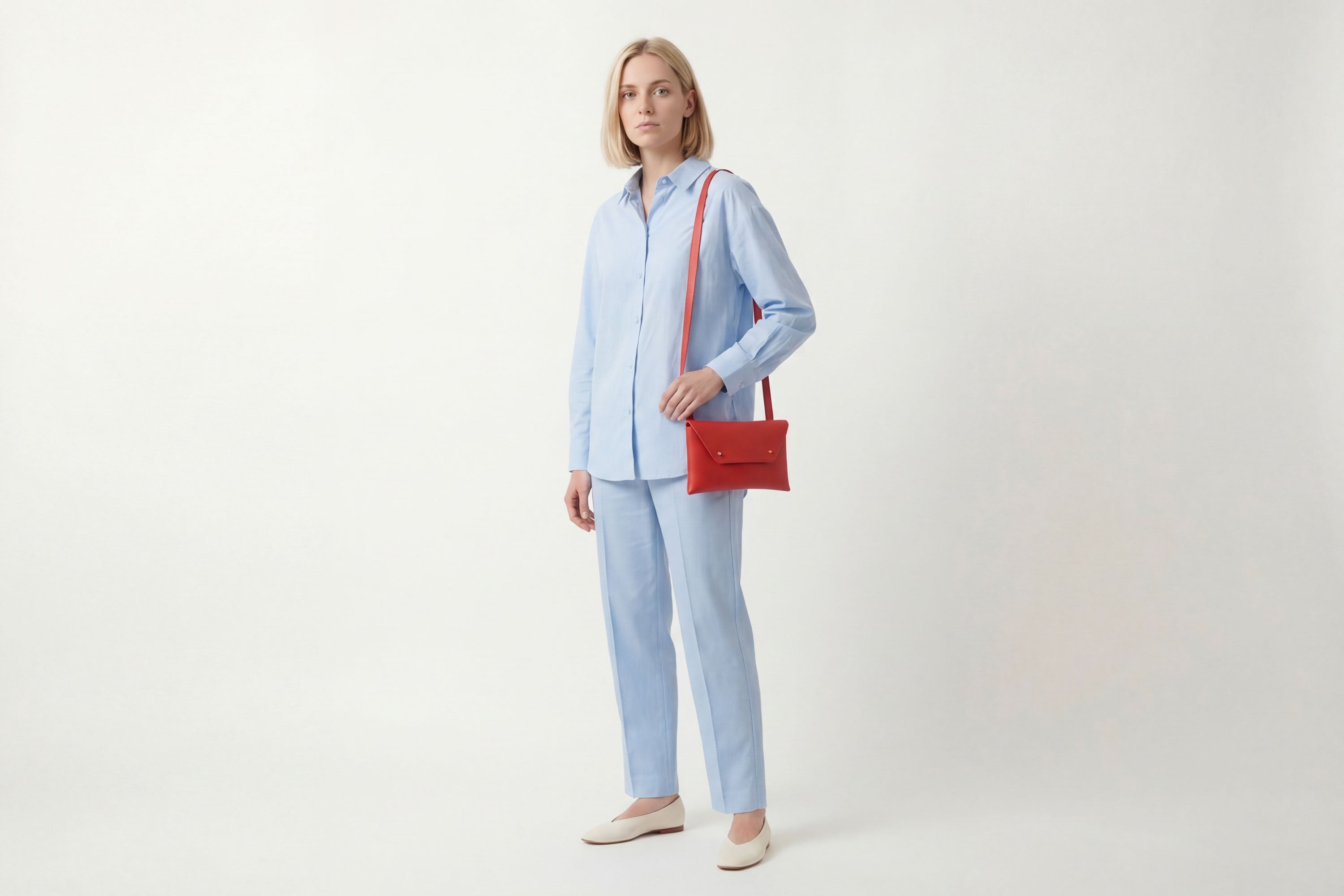 Envelope Bag With a Strap In Red Color On A Woman Model Vegetable Tanned Leather Minimalistic Design Atelier Madre Manuel Dreesmann Barcelona Spain