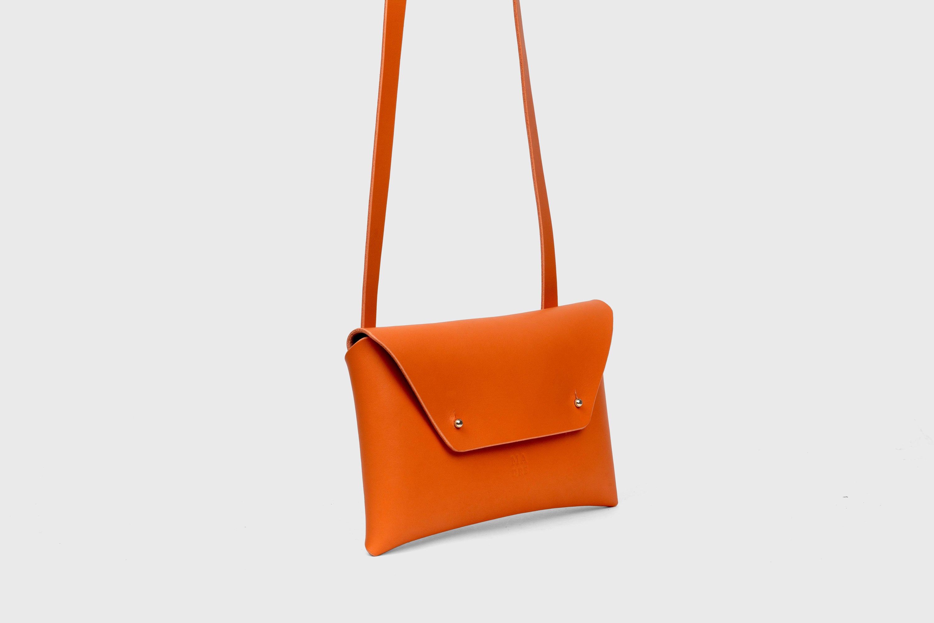 Envelope Bag With a Strap In Orange Color Vegetable Tanned Leather Minimalistic Design Atelier Madre Manuel Dreesmann Barcelona Spain