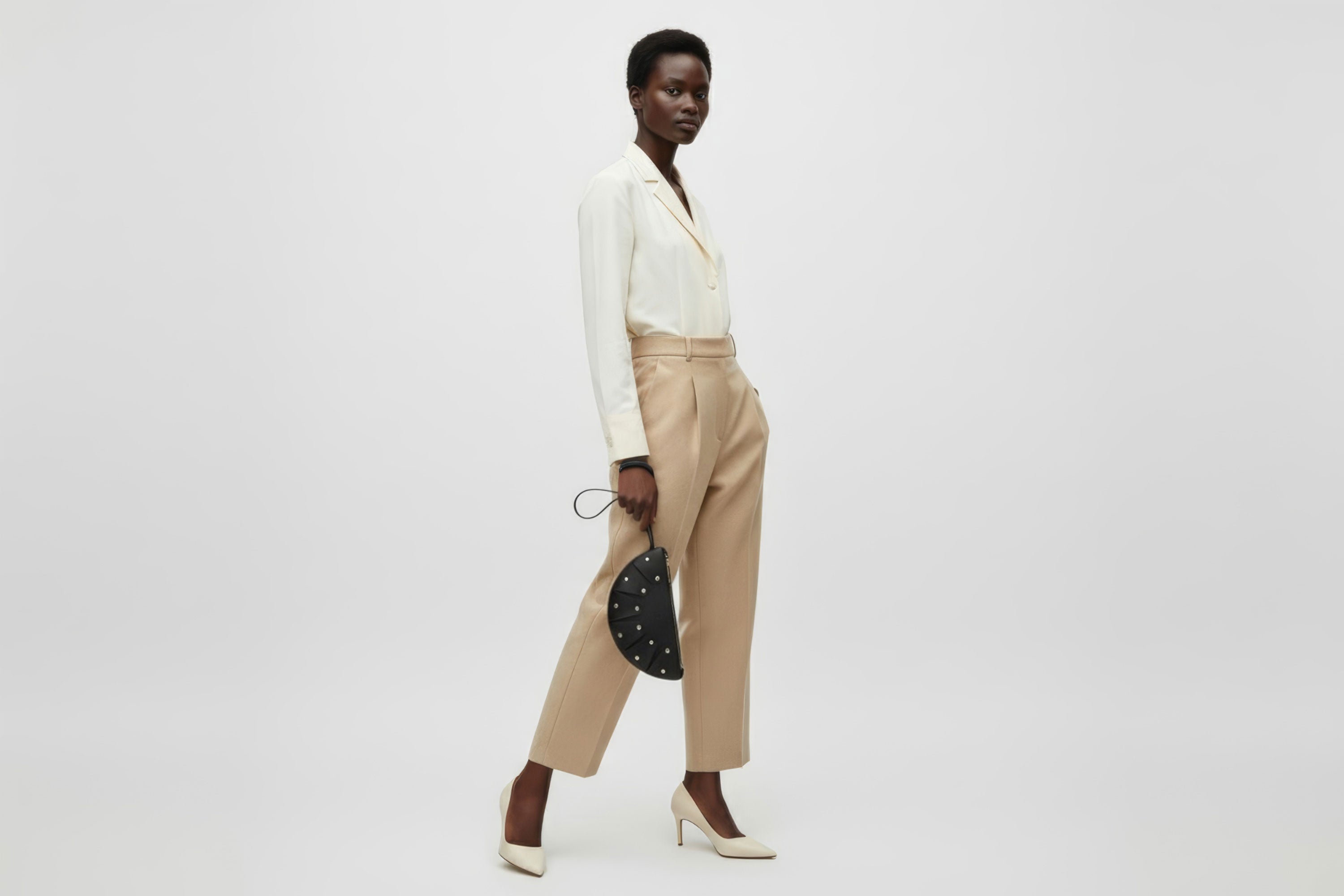 Juno Leather Bag Black Color On A Model Vegetable Tanned Full Grain Spain Brass Rivets Design Minimalist Half Moon Circle Round Zipper Pouch Handbag Clutch Bag Atelier Madre Manuel Dreesmann Barcelona