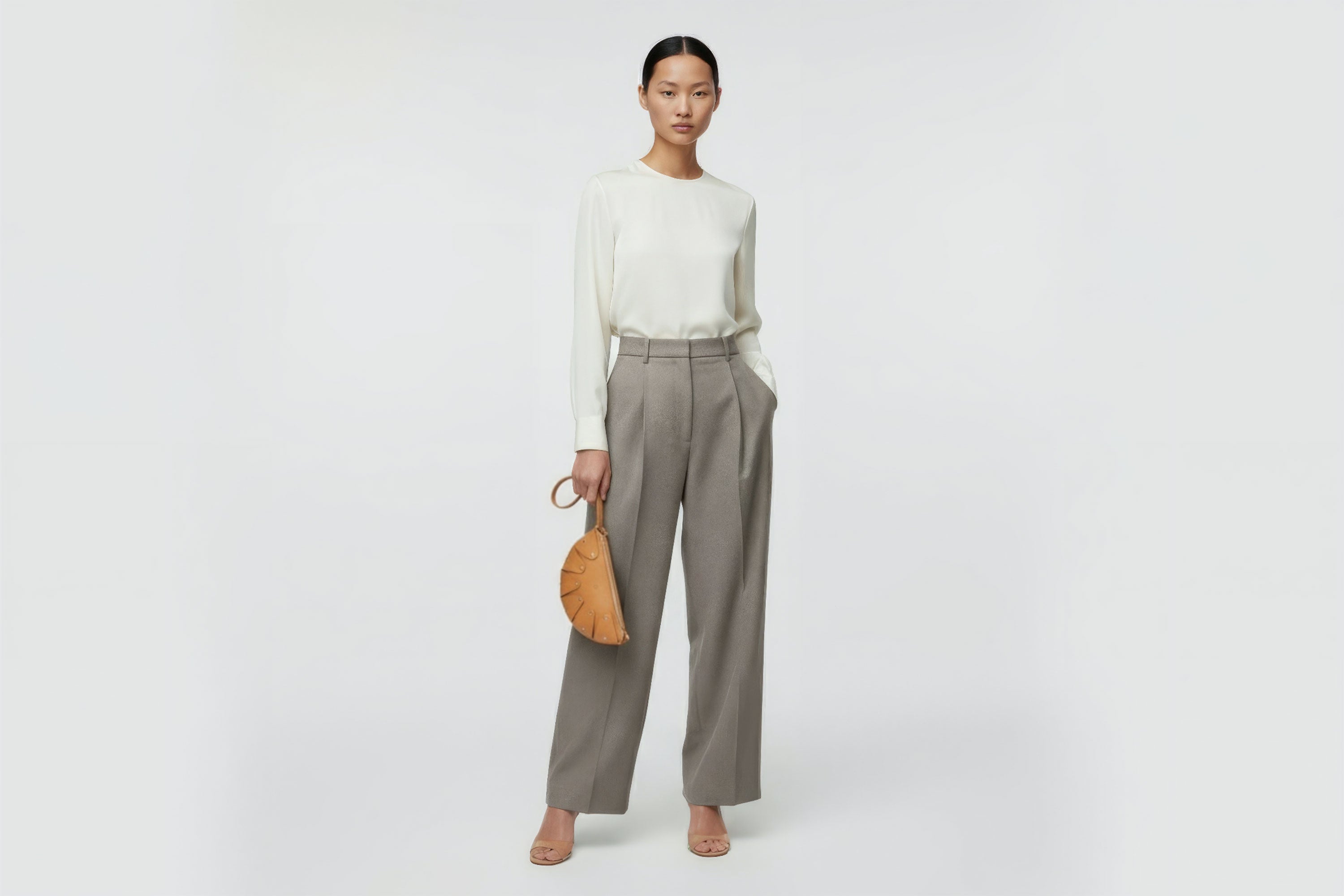 Juno Leather Clutch Bag Brown On A Model Vegetable Tanned Full Grain Spain Brass Rivets Design Minimalist Half Moon Circle Round Zipper Pouch Handbag Clutch Bag Atelier Madre Manuel Dreesmann Barcelona