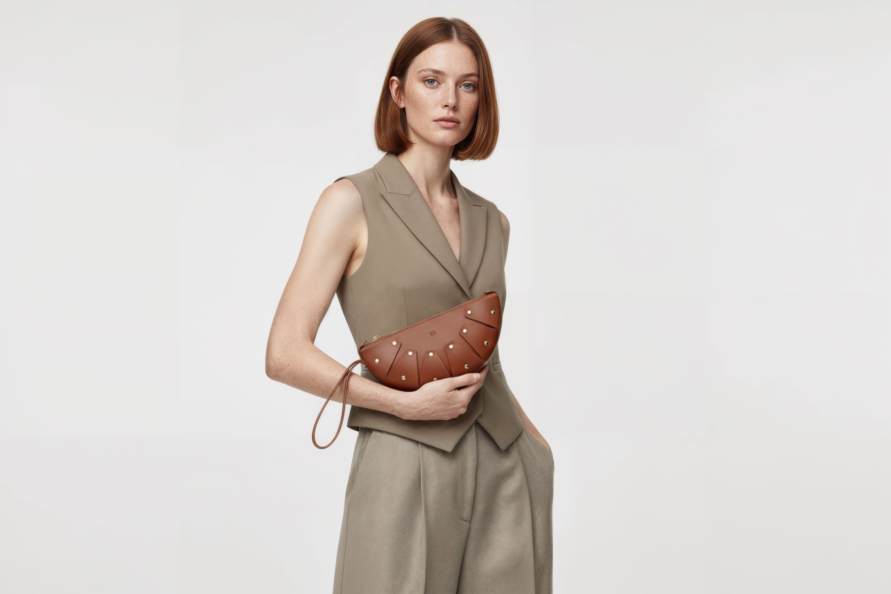 Juno Leather Bag Dark Brown On A Model Vegetable Tanned Full Grain Spain Brass Rivets Design Minimalist Half Moon Circle Round Zipper Pouch Handbag Clutch Bag Atelier Madre Manuel Dreesmann Barcelona