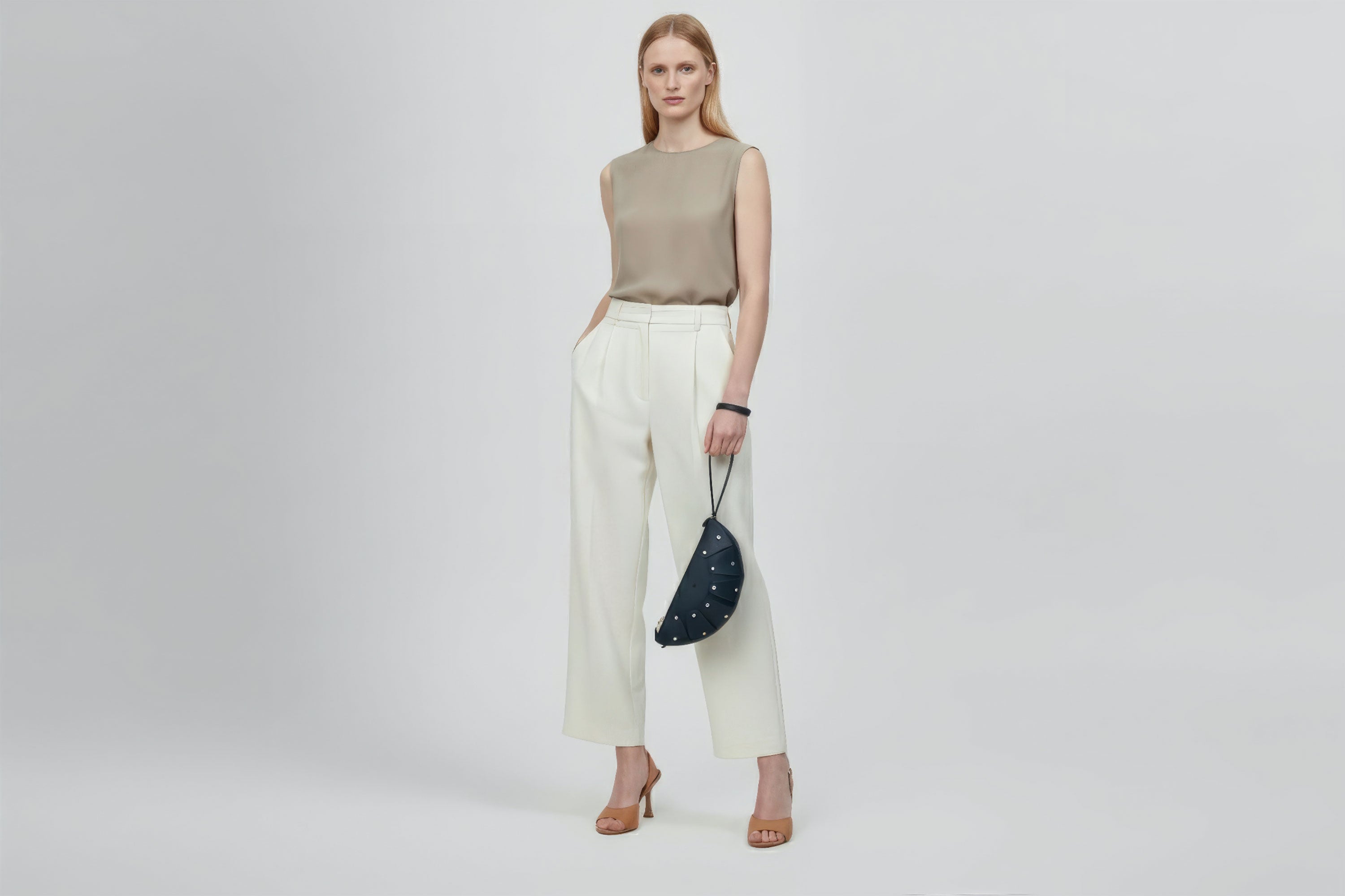 Juno Leather Bag Marine Blue Color On A Model Vegetable Tanned Full Grain Spain Brass Rivets Design Minimalist Half Moon Circle Round Zipper Pouch Handbag Clutch Bag Atelier Madre Manuel Dreesmann Barcelona