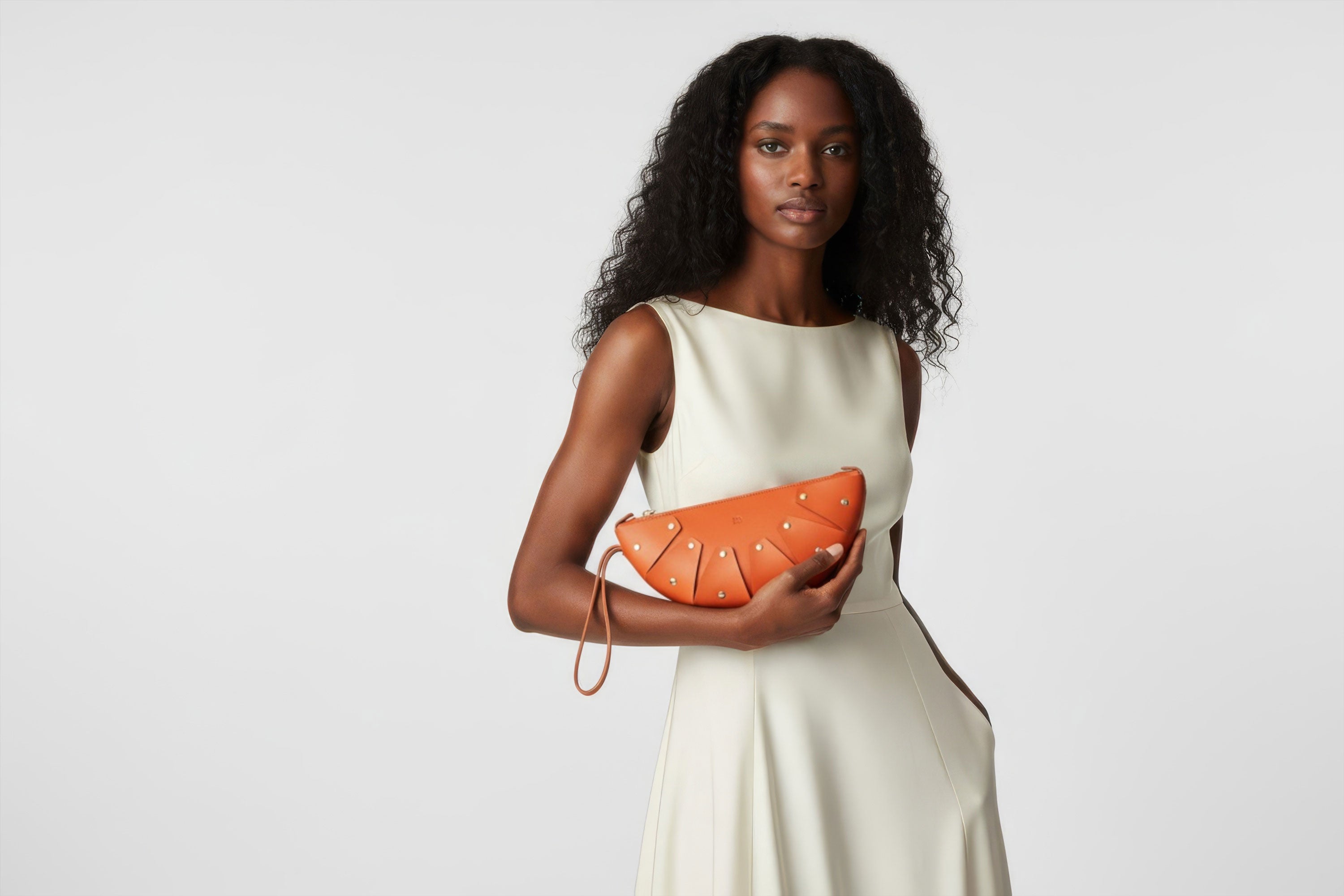 Juno Leather Bag Orange Color On A Model Vegetable Tanned Full Grain Spain Brass Rivets Design Minimalist Half Moon Circle Round Zipper Pouch Handbag Clutch Bag Atelier Madre Manuel Dreesmann Barcelona