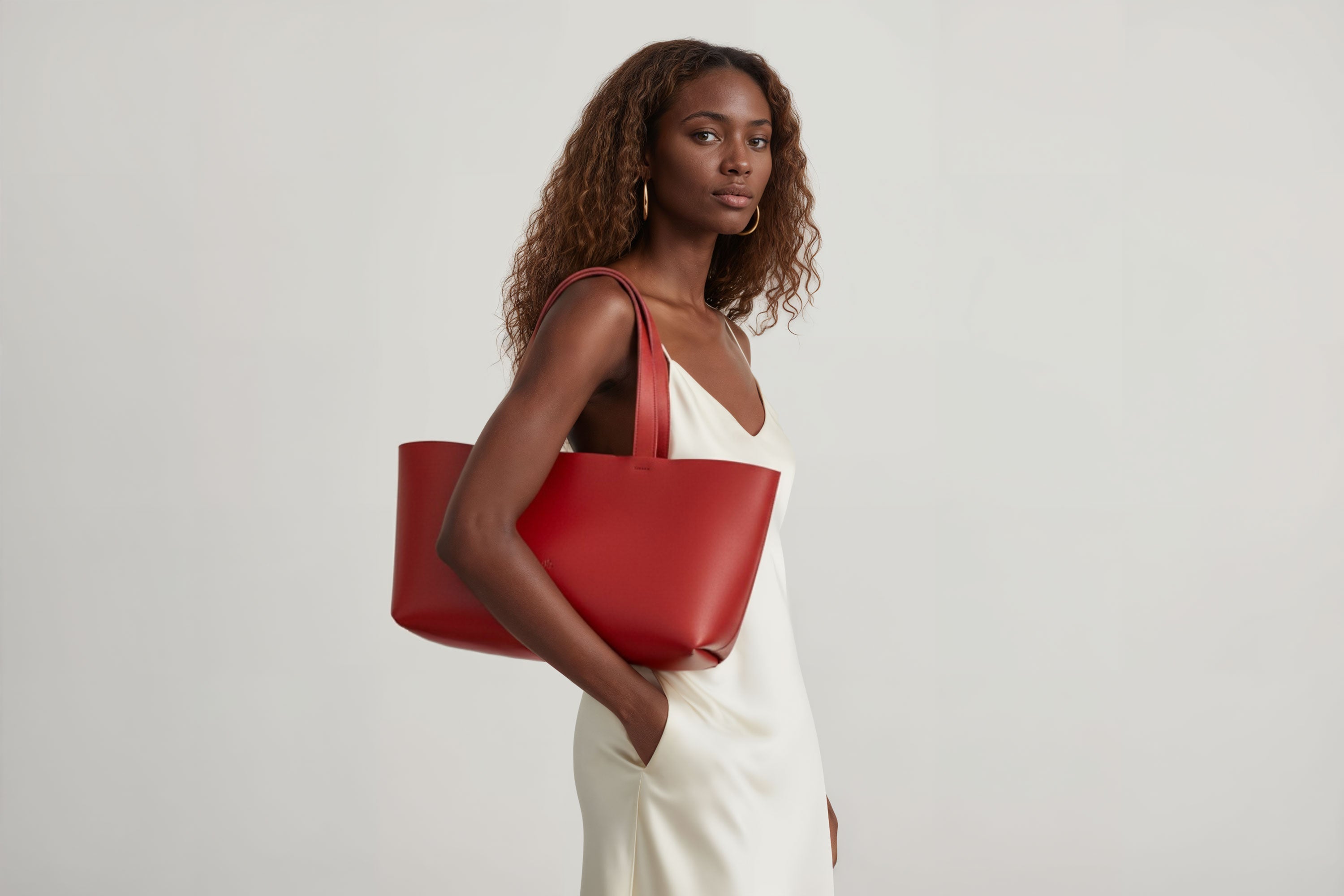 Karin Tote Bag Red Color On a Woman Model Vegetable Tanned Leather Vachetta Minimalistic Design Premium Atelier Madre Manuel Dreesmann Barcelona Spain