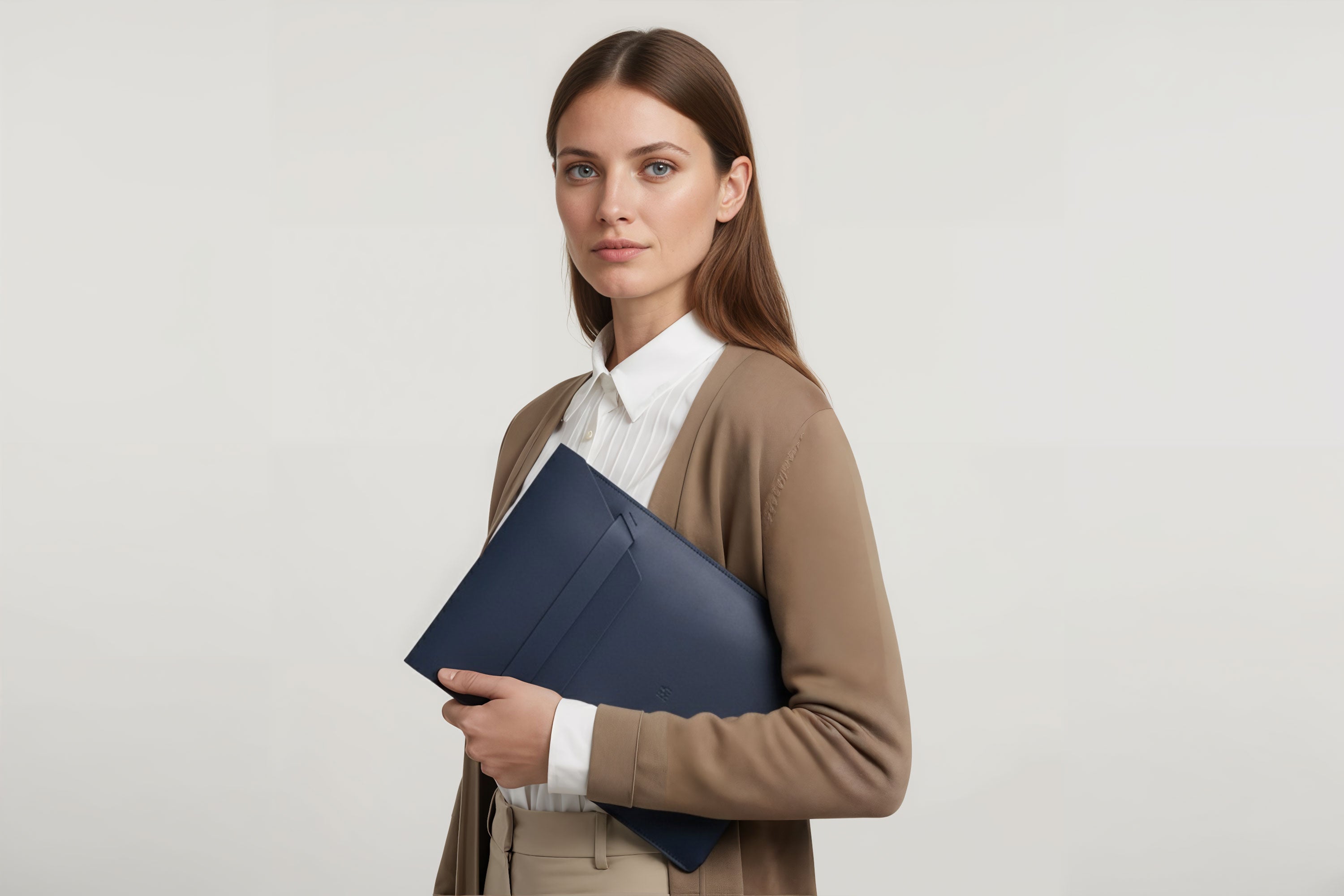 Woman holding a leather sleeve for a MacBook in marine blue color in front of bright background minimalistic design atelier Madre Manuel Dreesmann Barcelona Spain