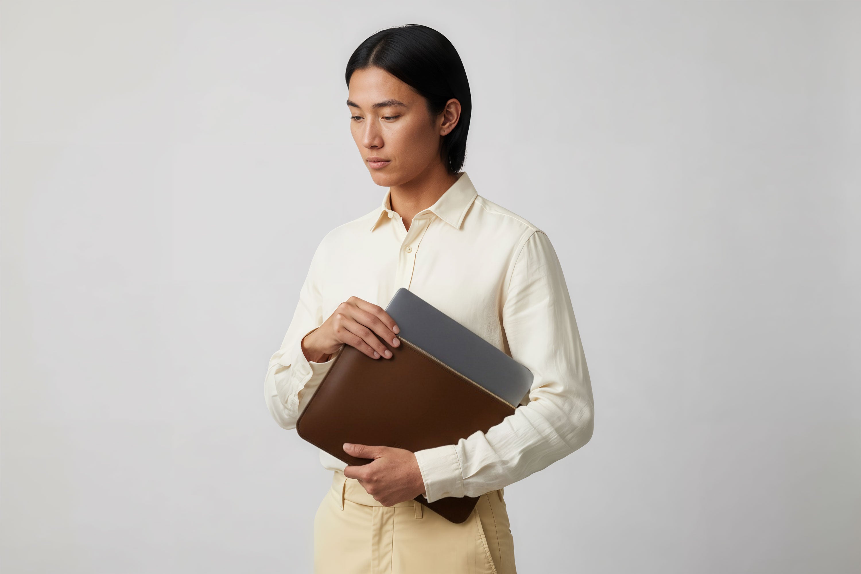 MacBook Sleeve Zipper Dark Brown Leather Horizontal On Model Grey Background Minimalistic Premium Design Atelier Madre Manuel Dreesmann Barcelona