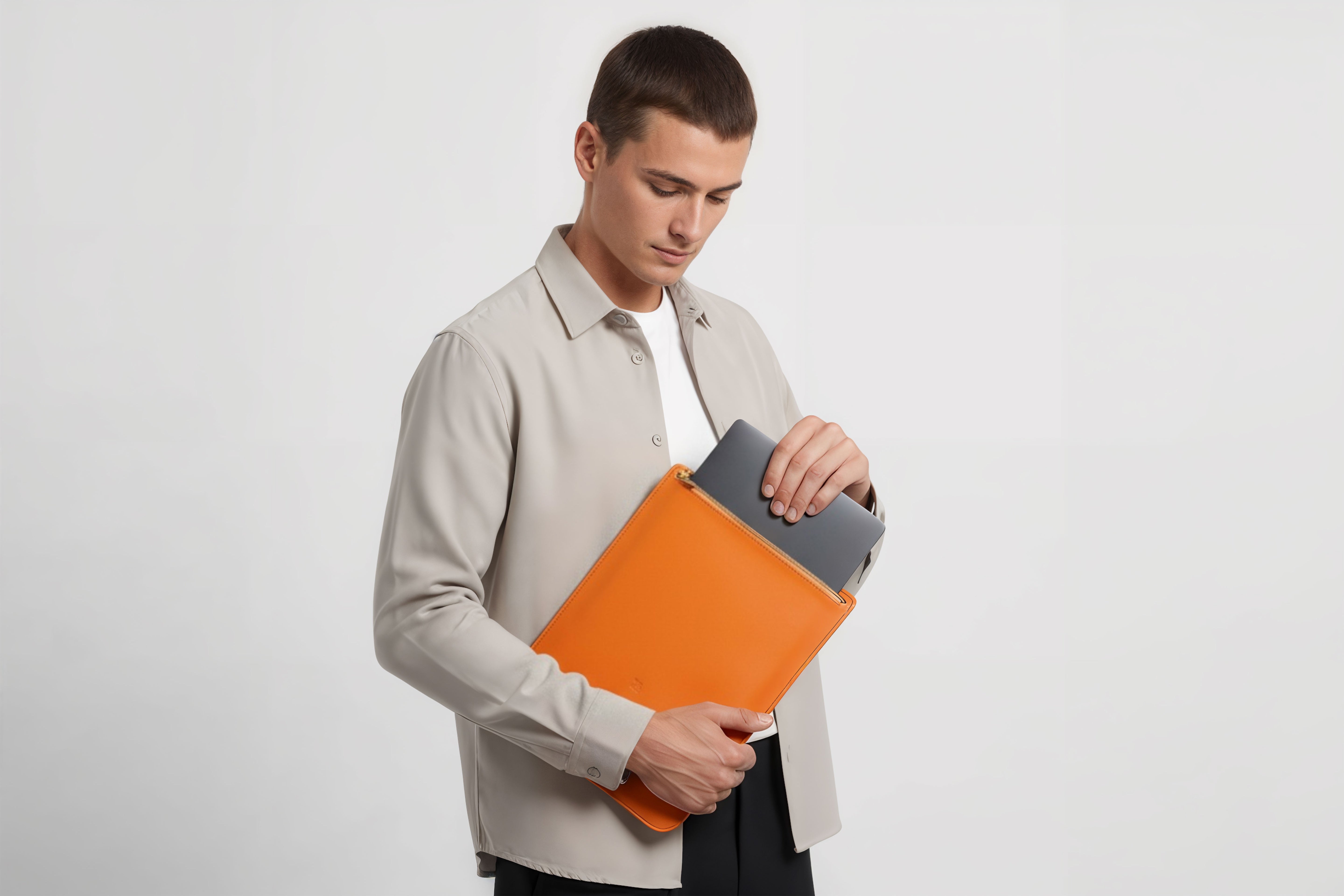 MacBook Sleeve Zipper Orange Leather Vertical On Man Model Grey Background Minimalistic Premium Design Atelier Madre Manuel Dreesmann Barcelona