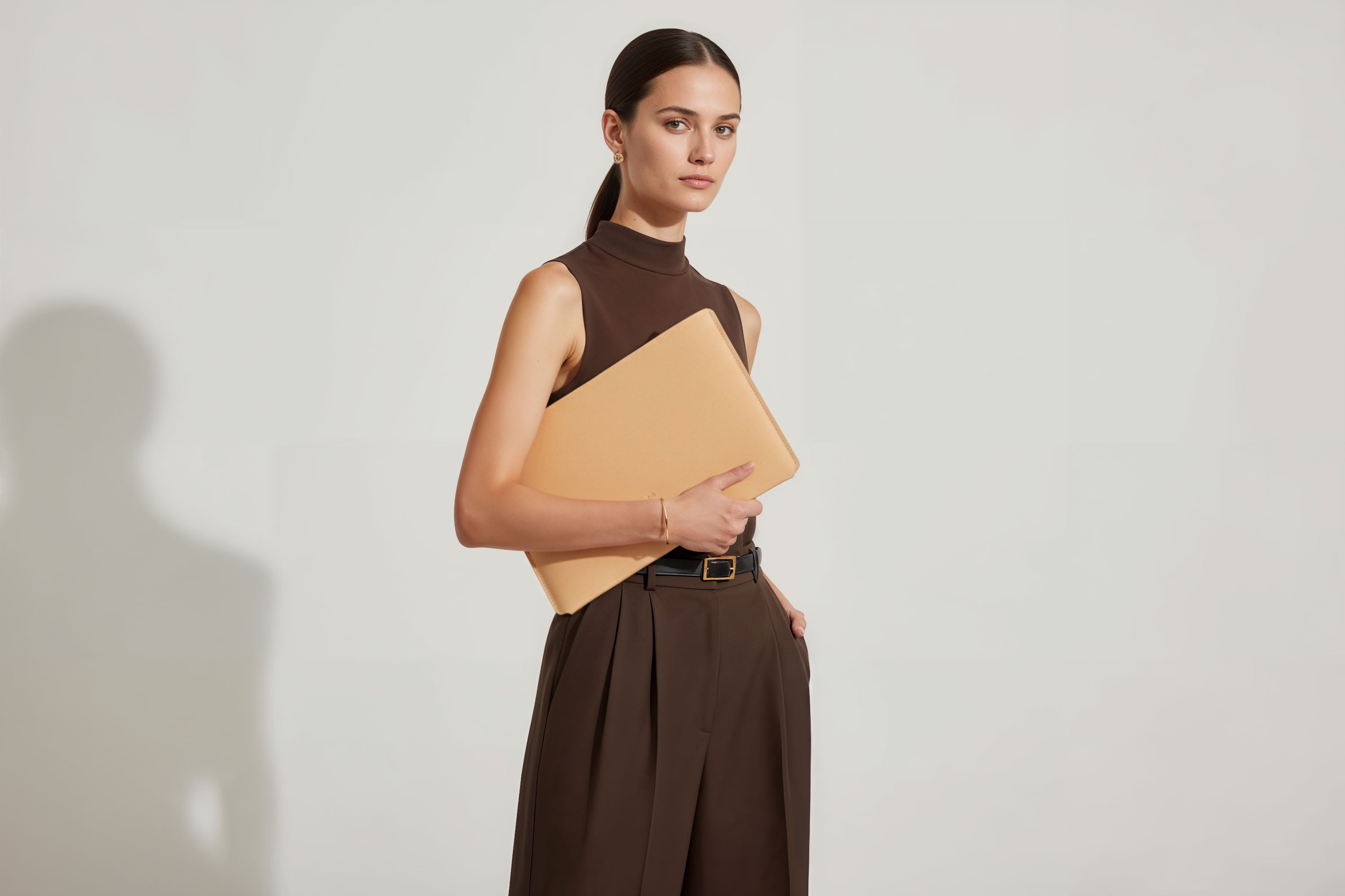 MacBook Slip Sleeve Natural Leather Horizontal On Model Grey Background Minimalistic Premium Design Atelier Madre Manuel Dreesmann Barcelona