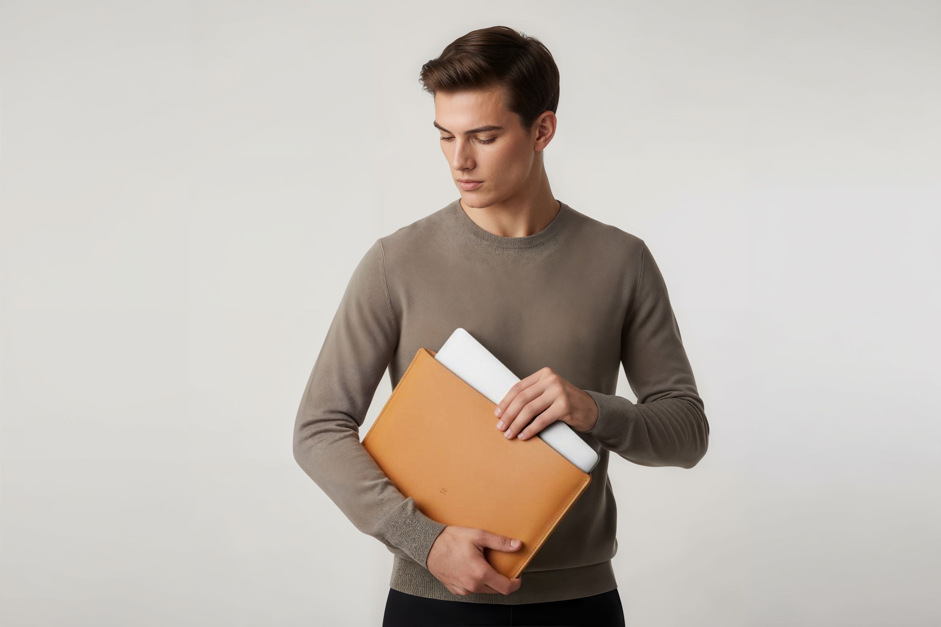 MacBook Slip Sleeve Brown Leather Horizontal On Model Grey Background Minimalistic Premium Design Atelier Madre Manuel Dreesmann Barcelona