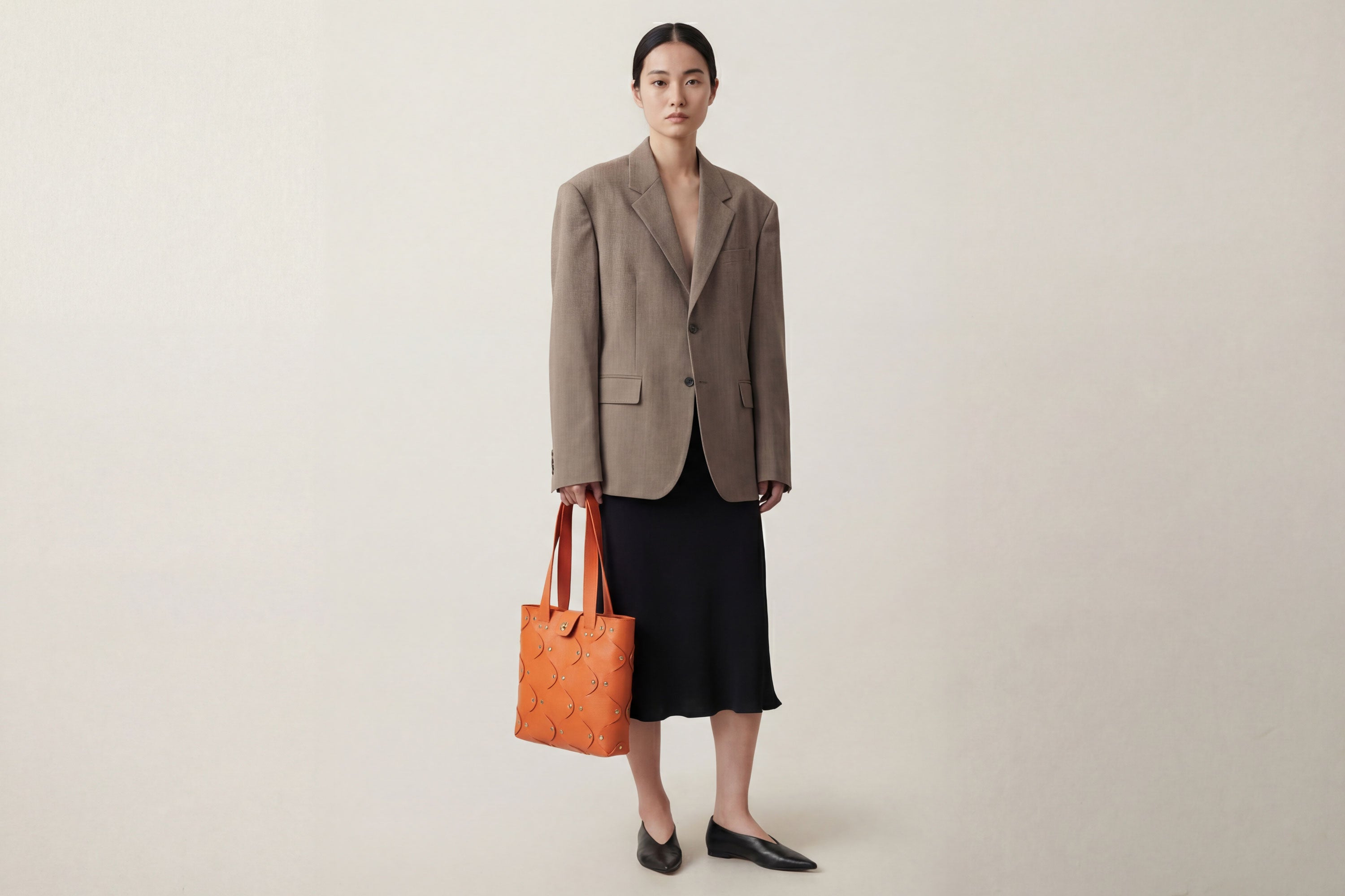 Marlin Tote Bag In Orange Color On Model In Vegetable Tanned Leather With Rivets Atelier Madre Manuel Dreesmann Barcelona Spain