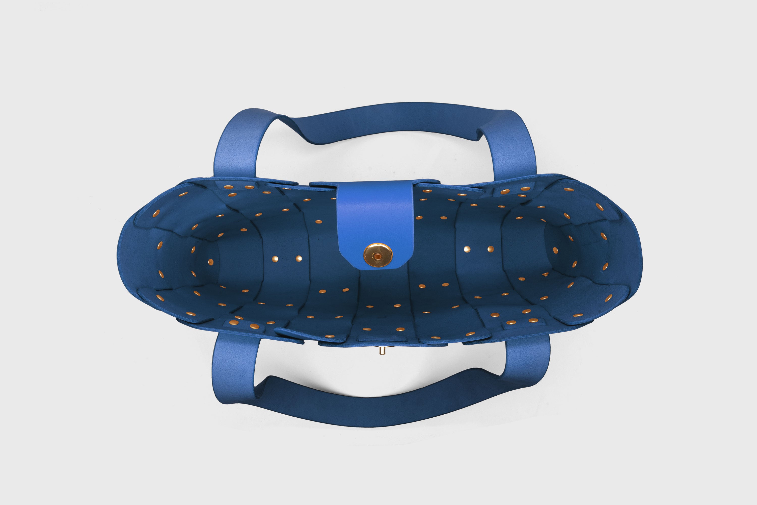 Marlin Tote Bag In Royal Blue Color On Model In Vegetable Tanned Leather With Rivets Atelier Madre Manuel Dreesmann Barcelona Spain