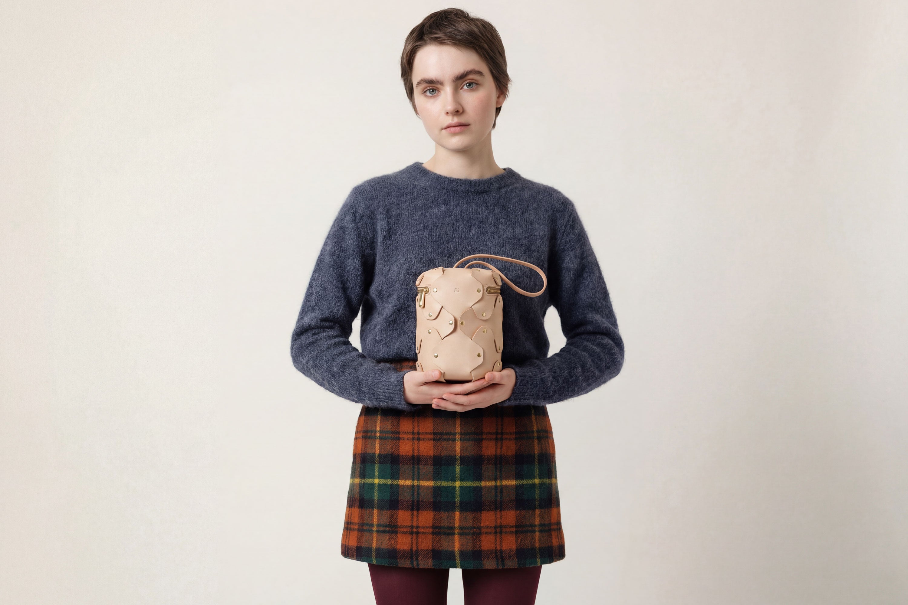 Nema Leather Bag Natural Color On A Woman Model Vegetable Tanned Full Grain Spain Brass Rivets Premium Design Minimalist Modern Cylinder Circle Round Zipper Pouch Handbag Atelier Madre Manuel Dreesmann Barcelona