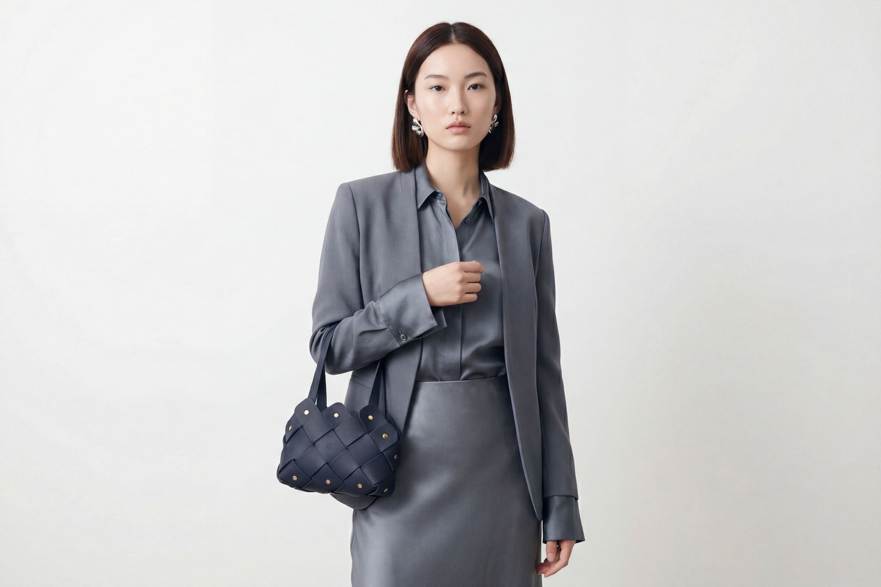 Pine Mini Tote Bag In Marine Blue Color In Vegetable Tanned Leather On Woman Model Woven Technique and Brass Rivets Atelier Madre Manuel Dreesmann Barcelona Spain