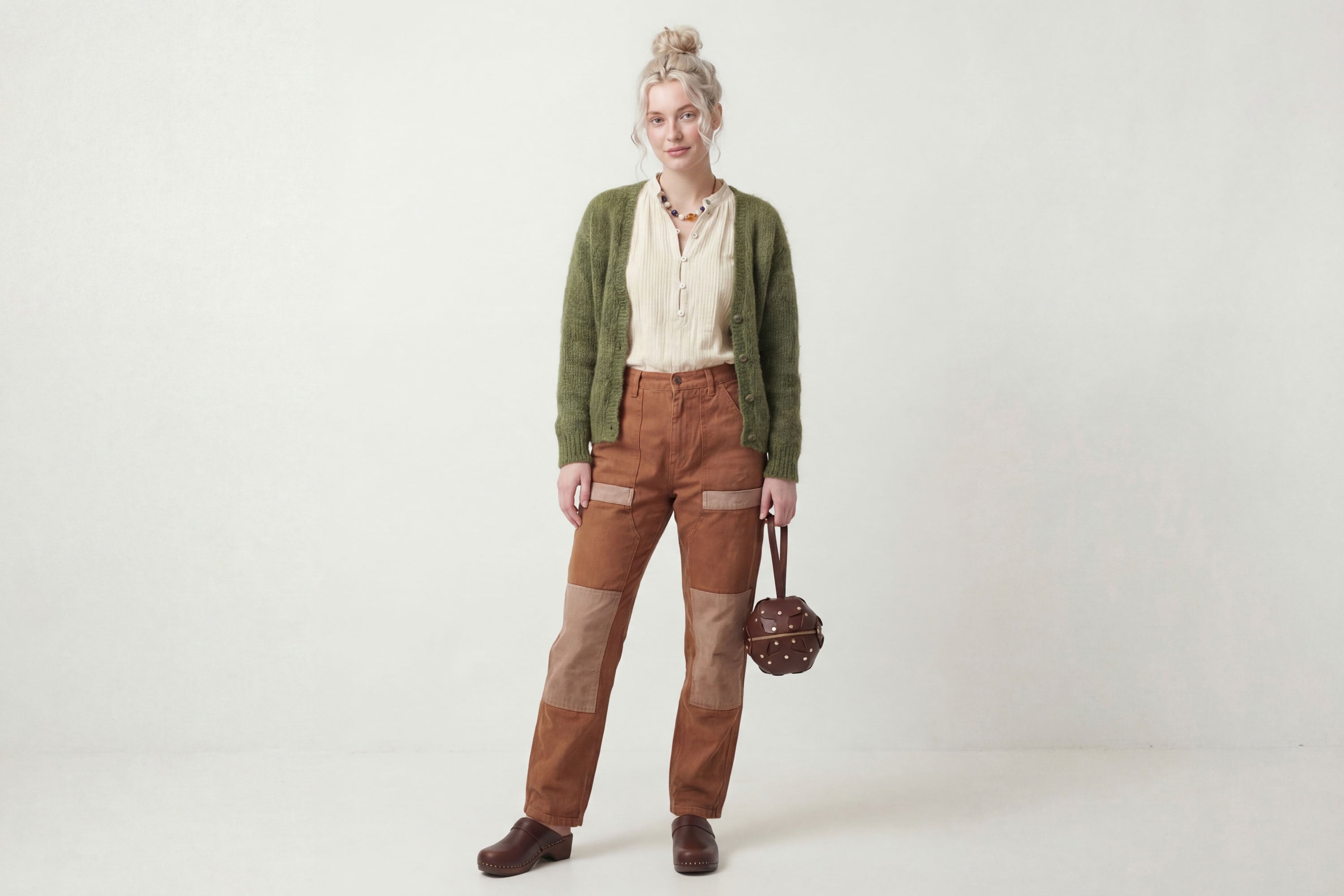 Puff Leather Ball Bag Dark Brown Color On A Woman Model Luxury Vegetable Tanned Full Grain Spain Brass Rivets Premium Design Minimalist Modern Round Sphere Circle Round Zipper Pouch Handbag Clutch Bag Atelier Madre Manuel Dreesmann Barcelona