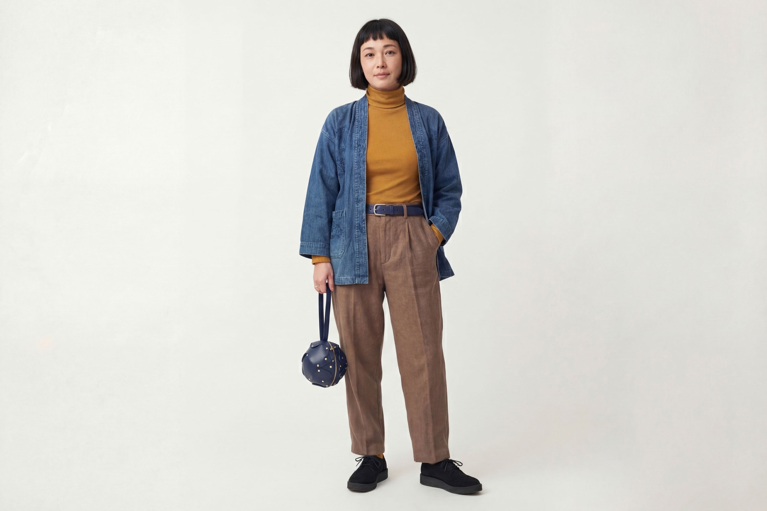 Puff Leather Ball Bag Marine Blue Color On A Woman Model Luxury Vegetable Tanned Full Grain Spain Brass Rivets Premium Design Minimalist Modern Round Sphere Circle Round Zipper Pouch Handbag Clutch Bag Atelier Madre Manuel Dreesmann Barcelona