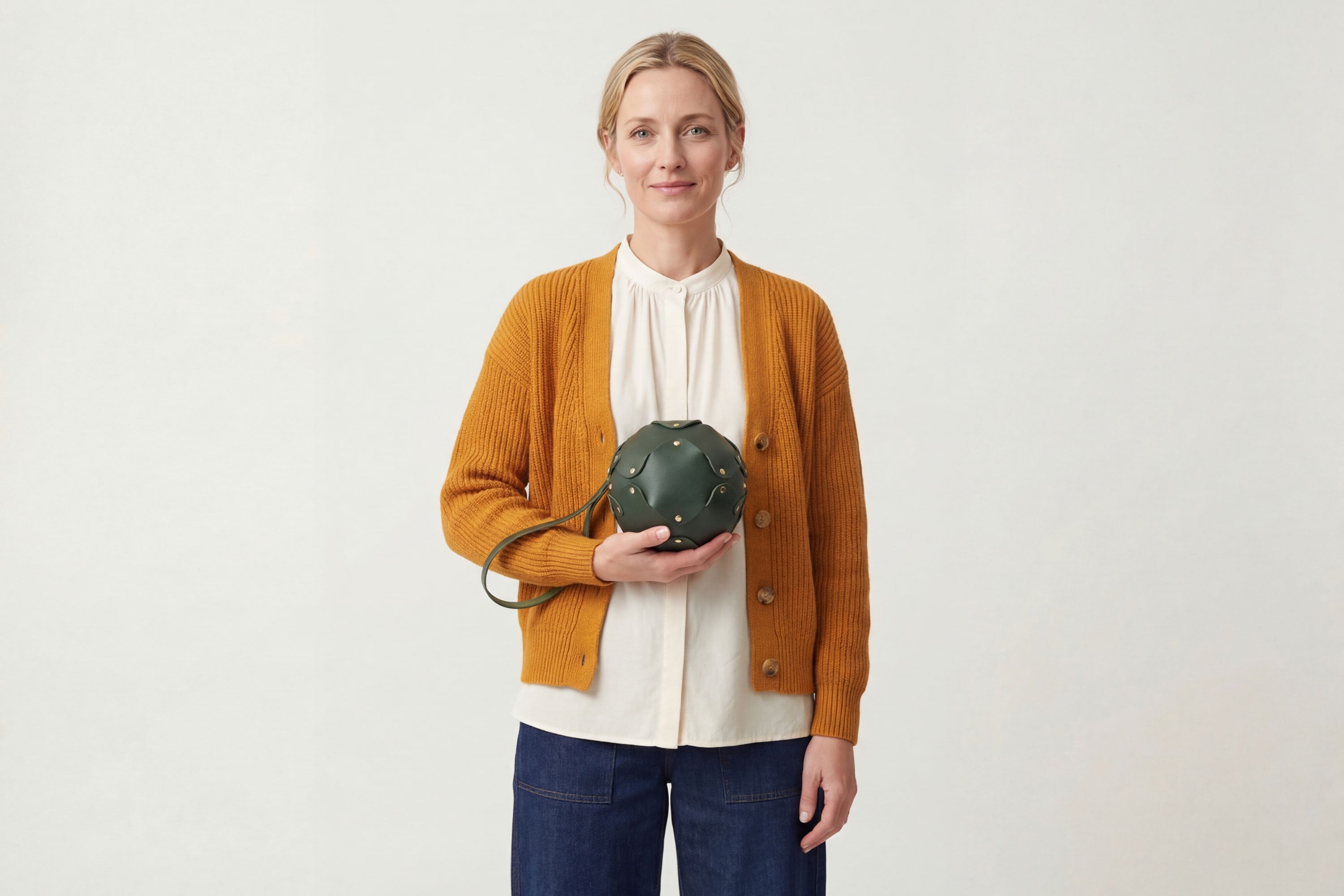 Puff Leather Ball Bag Olive Green Color On A Woman Model Luxury Vegetable Tanned Full Grain Spain Brass Rivets Premium Design Minimalist Modern Round Sphere Circle Round Zipper Pouch Handbag Clutch Bag Atelier Madre Manuel Dreesmann Barcelona