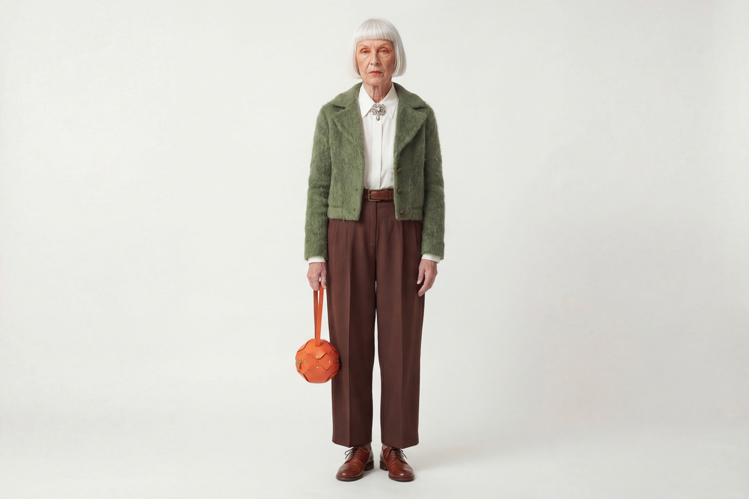 Puff Leather Ball Bag Orange Color On A Woman Model Luxury Vegetable Tanned Full Grain Spain Brass Rivets Premium Design Minimalist Modern Round Sphere Circle Round Zipper Pouch Handbag Clutch Bag Atelier Madre Manuel Dreesmann Barcelona