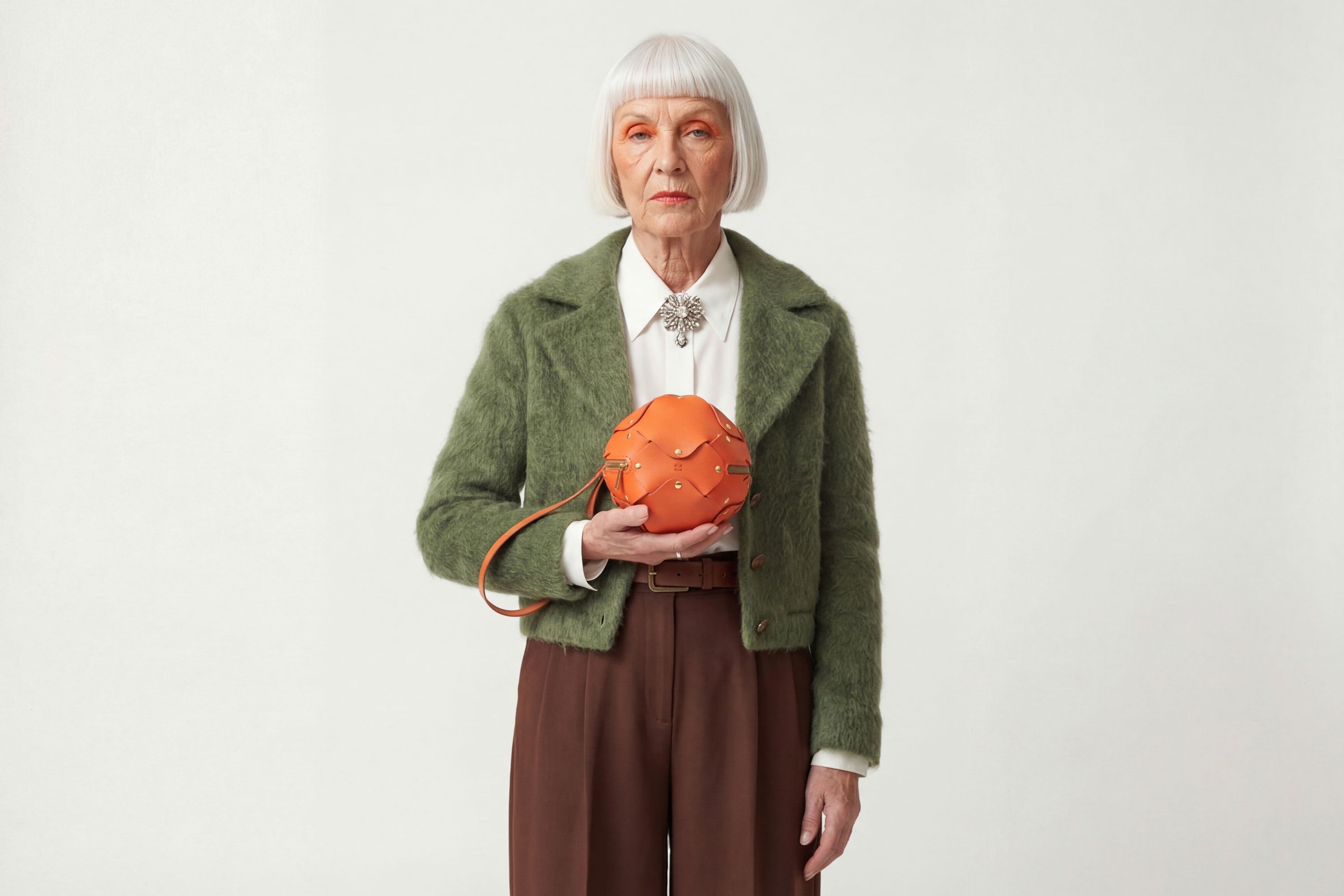 Puff Leather Ball Bag Orange Color On A Woman Model Luxury Vegetable Tanned Full Grain Spain Brass Rivets Premium Design Minimalist Modern Round Sphere Circle Round Zipper Pouch Handbag Clutch Bag Atelier Madre Manuel Dreesmann Barcelona