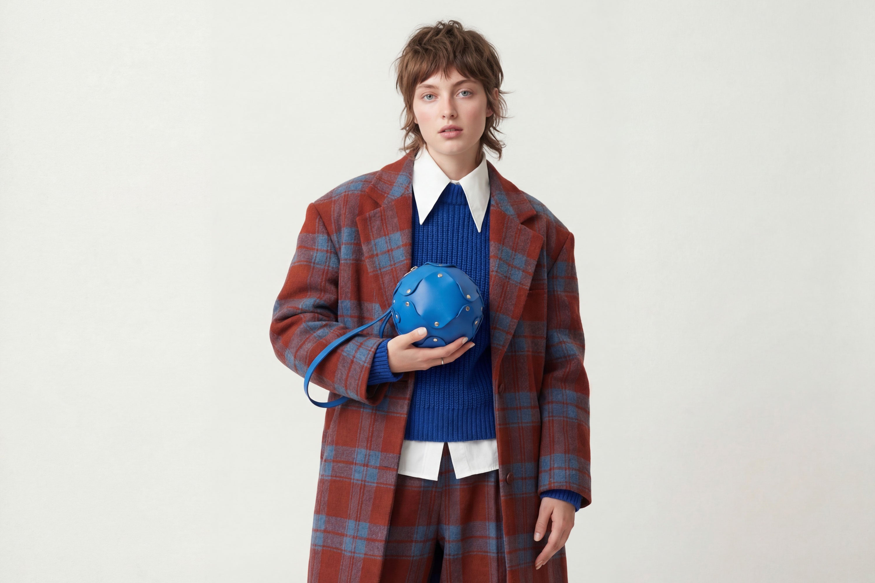 Puff Leather Ball Bag Royal Blue Color On A Woman Model Luxury Vegetable Tanned Full Grain Spain Brass Rivets Premium Design Minimalist Modern Round Sphere Circle Round Zipper Pouch Handbag Clutch Bag Atelier Madre Manuel Dreesmann Barcelona