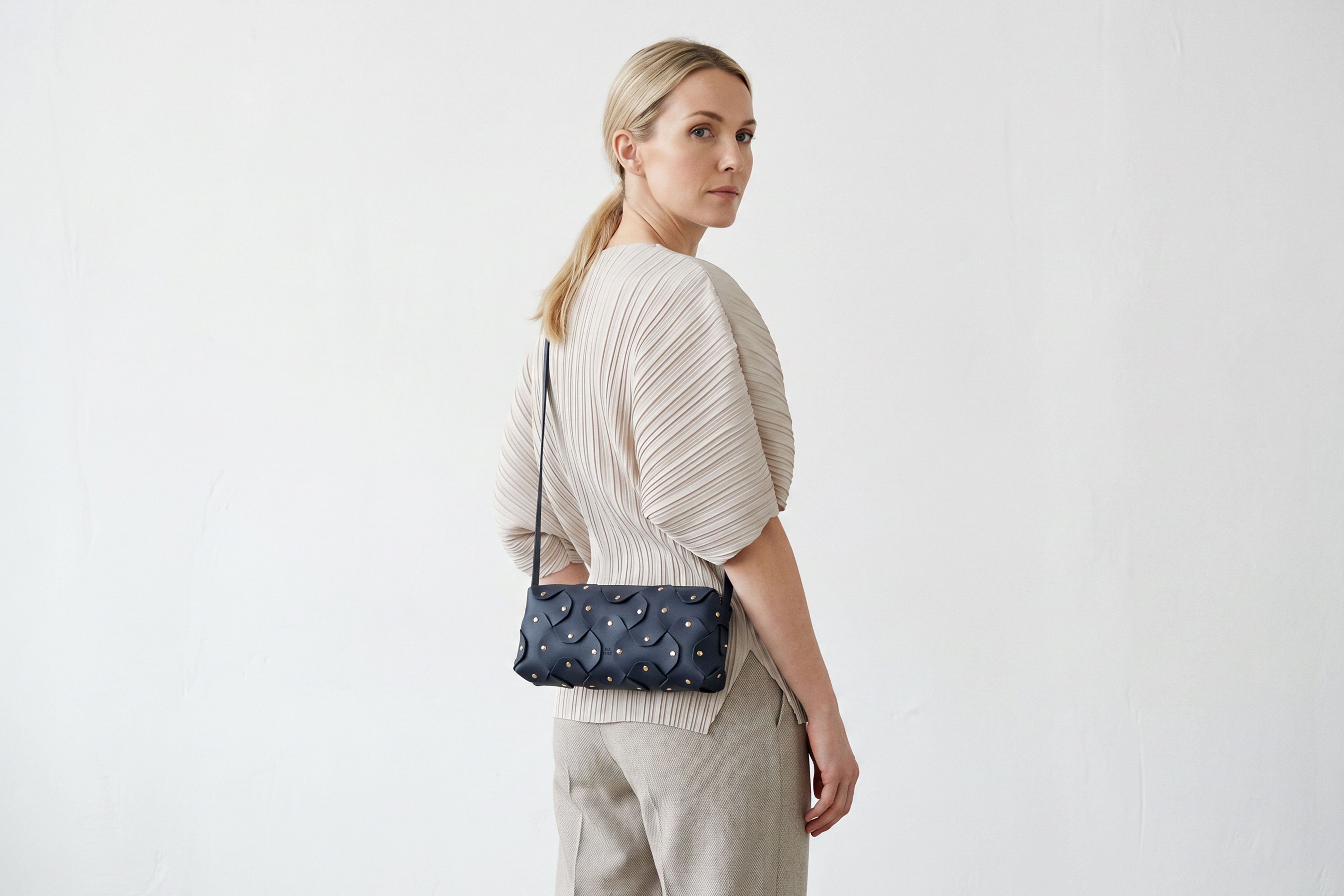 Rivet Bag 01 In Marine Blue Color On A Woman Model In Vegetable Tanned Leather With Brass Rivets Unique Design Atelier Madre Manuel Dreesmann Barcelona Spain
