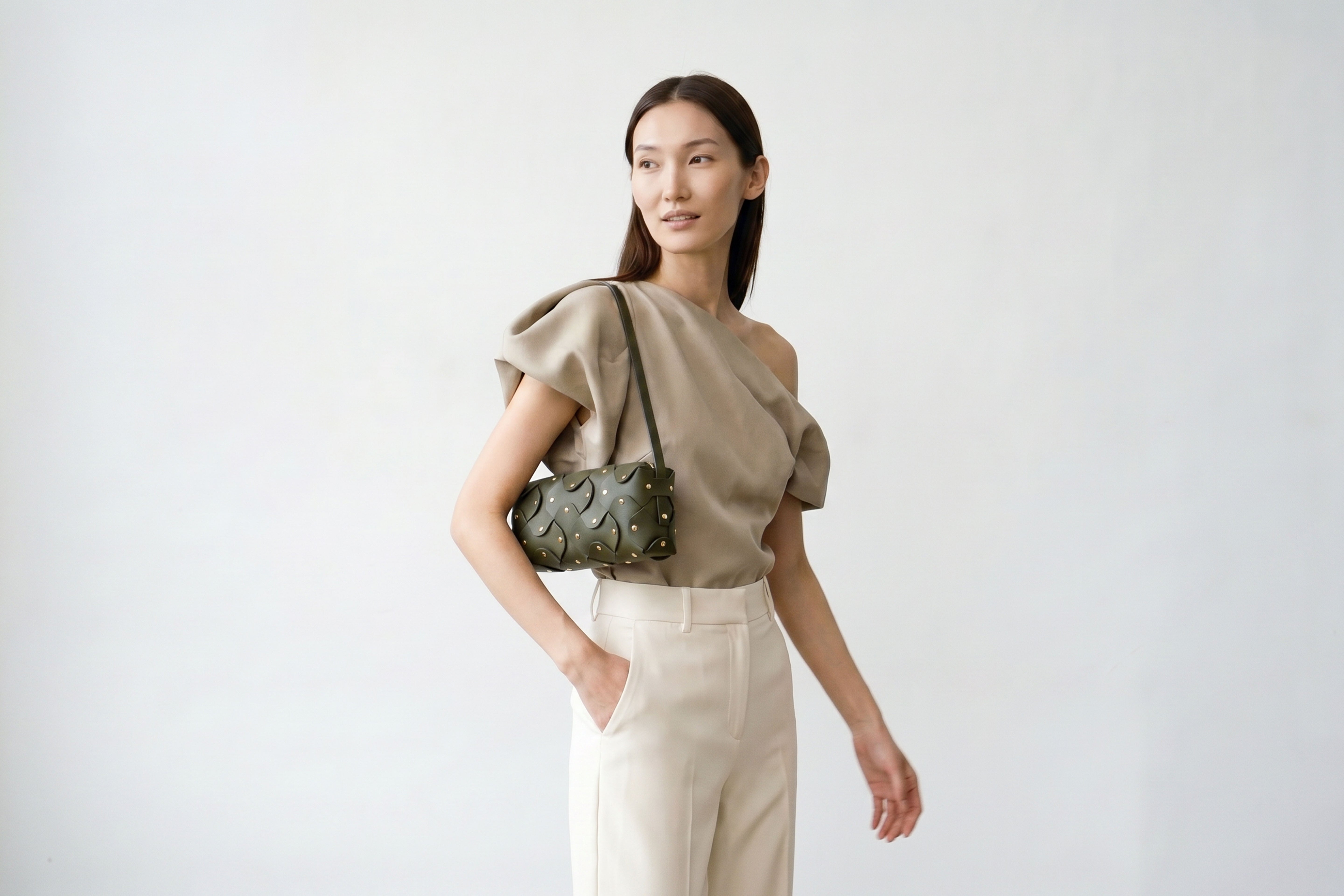 Rivet Bag 01 In Olive Green Color On A Woman Model In Vegetable Tanned Leather With Brass Rivets Unique Design Atelier Madre Manuel Dreesmann Barcelona Spain