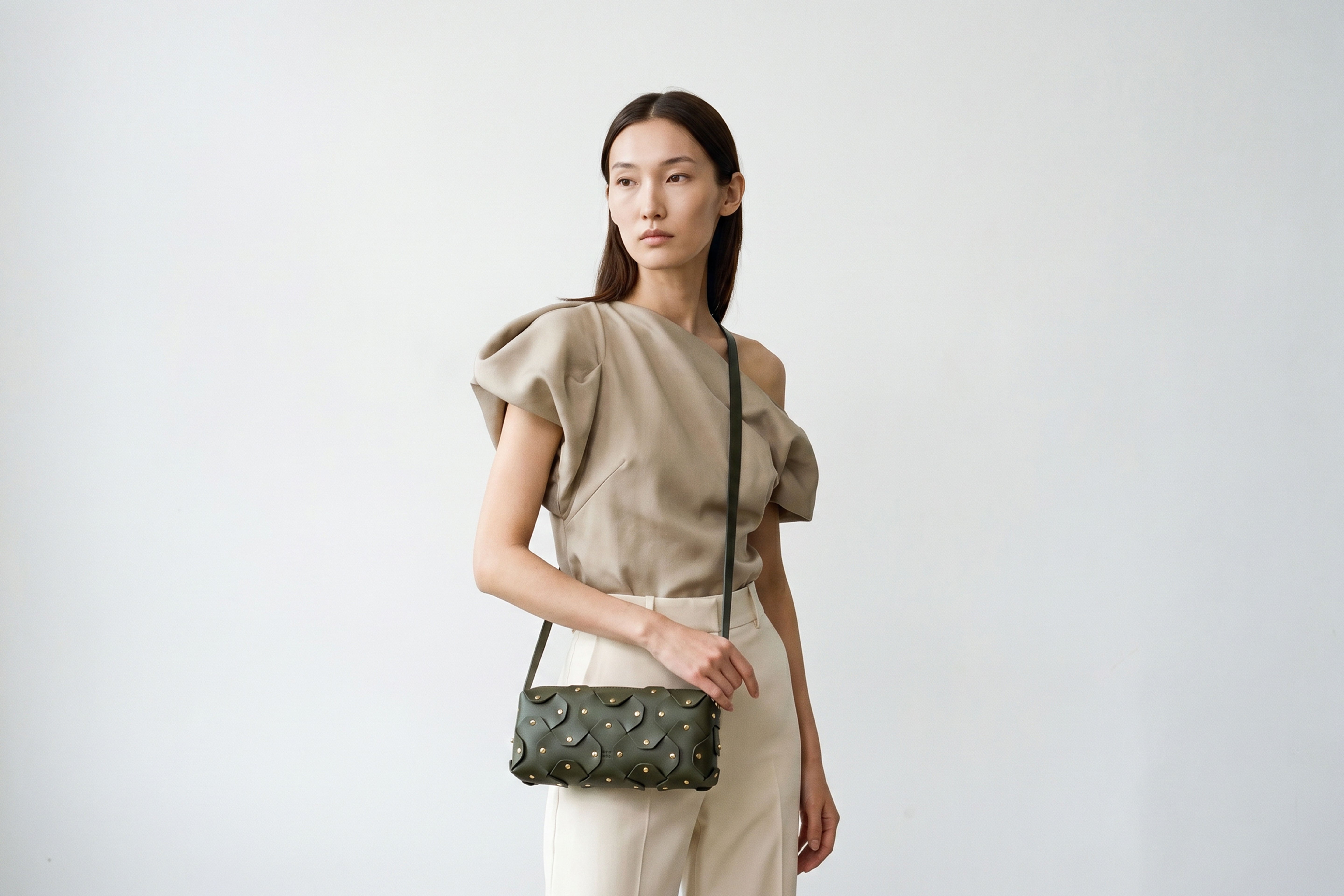 Rivet Bag 01 In Olive Green Color On A Woman Model In Vegetable Tanned Leather With Brass Rivets Unique Design Atelier Madre Manuel Dreesmann Barcelona Spain