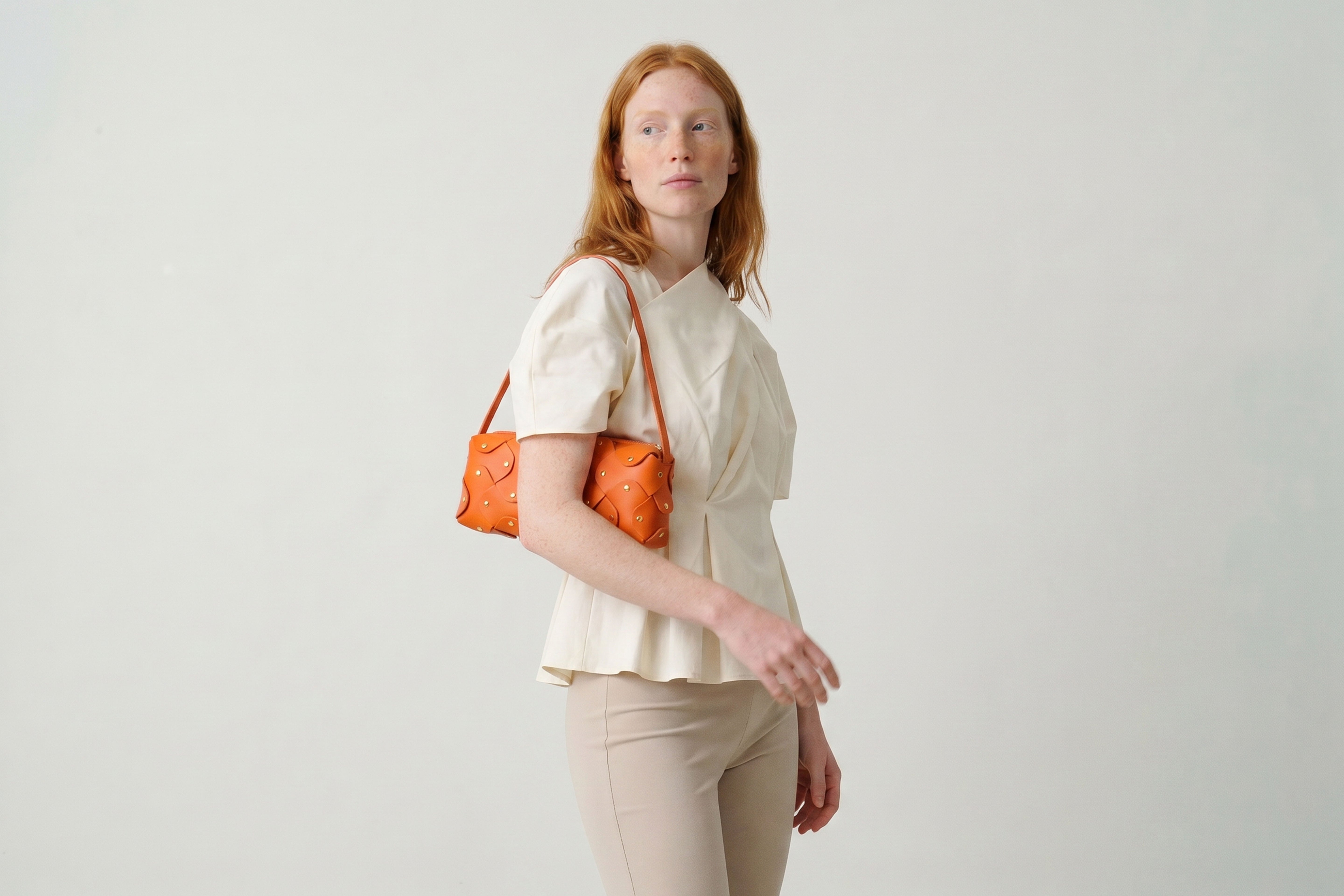 Rivet Bag 01 In Orange Color On A Woman Model In Vegetable Tanned Leather With Brass Rivets Unique Design Atelier Madre Manuel Dreesmann Barcelona Spain