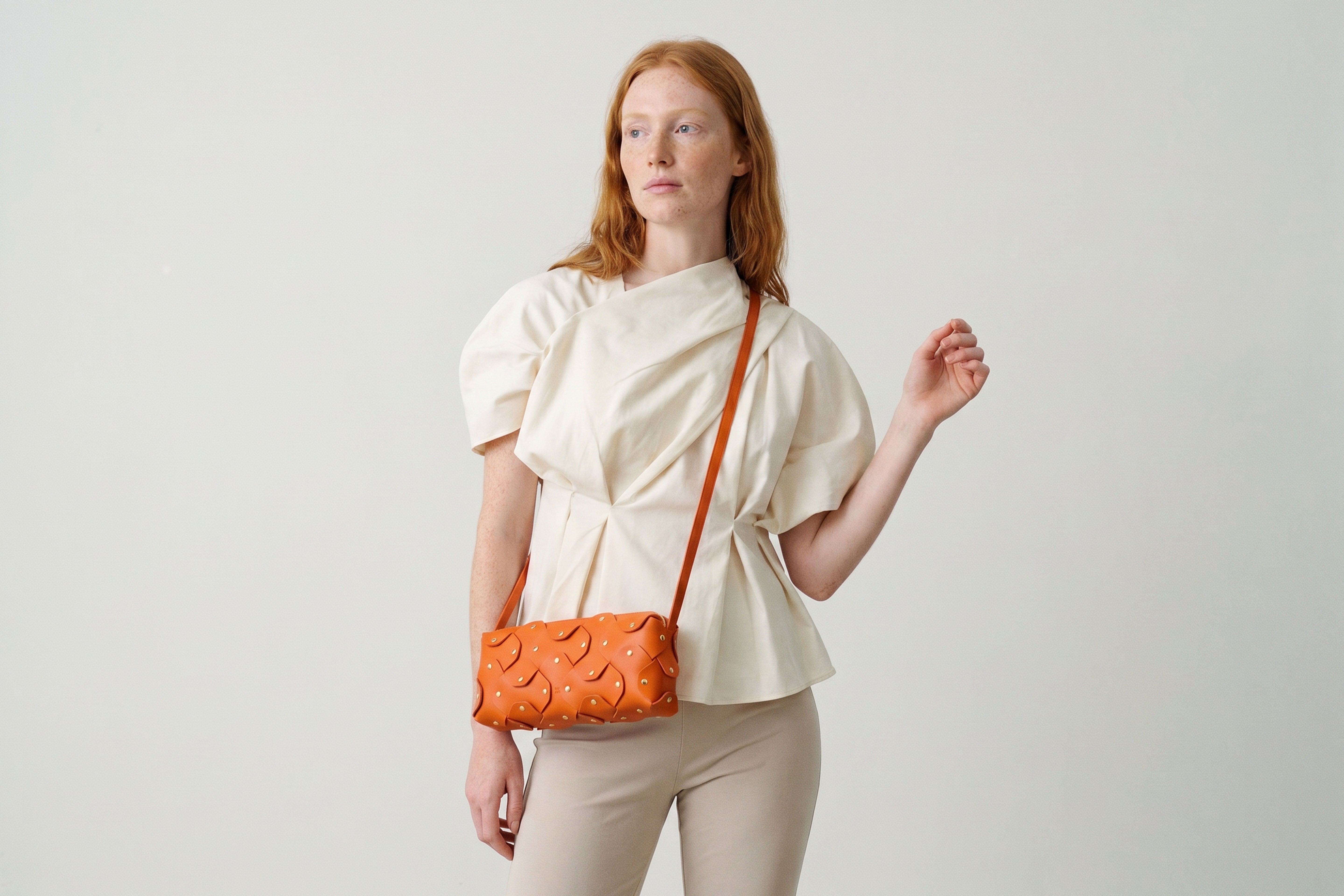 Rivet Bag 01 In Orange Color On A Woman Model In Vegetable Tanned Leather With Brass Rivets Unique Design Atelier Madre Manuel Dreesmann Barcelona Spain