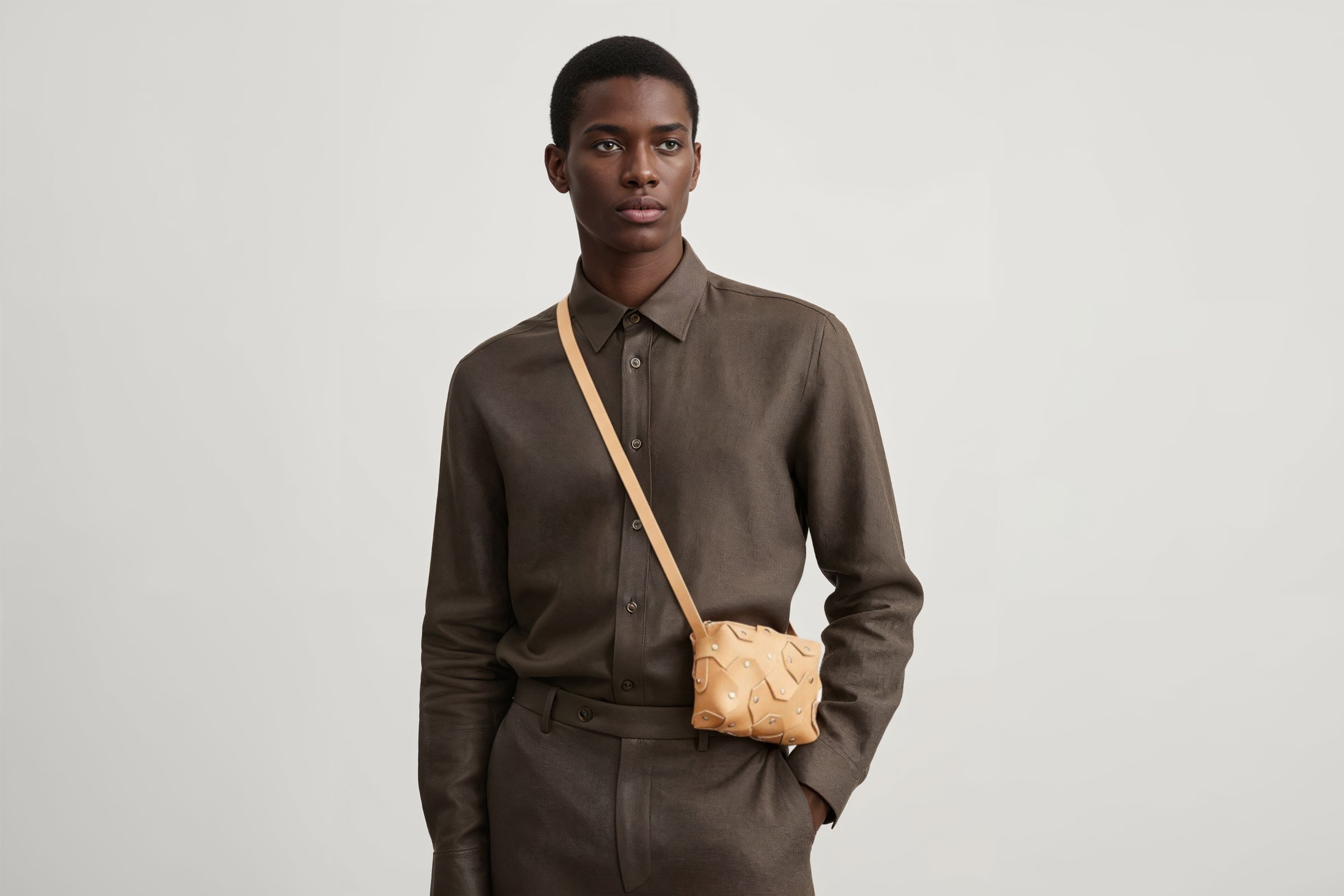 Rivet Bag Small Leather Natural Color On A Man Model Clutch Crossbody Shoulder Detachable Full Brass Vegetable Tanned Full Grain Leather High Quality Modern Minimalistic Design Atelier Madre Manuel Dreesmann Barcelona Spain