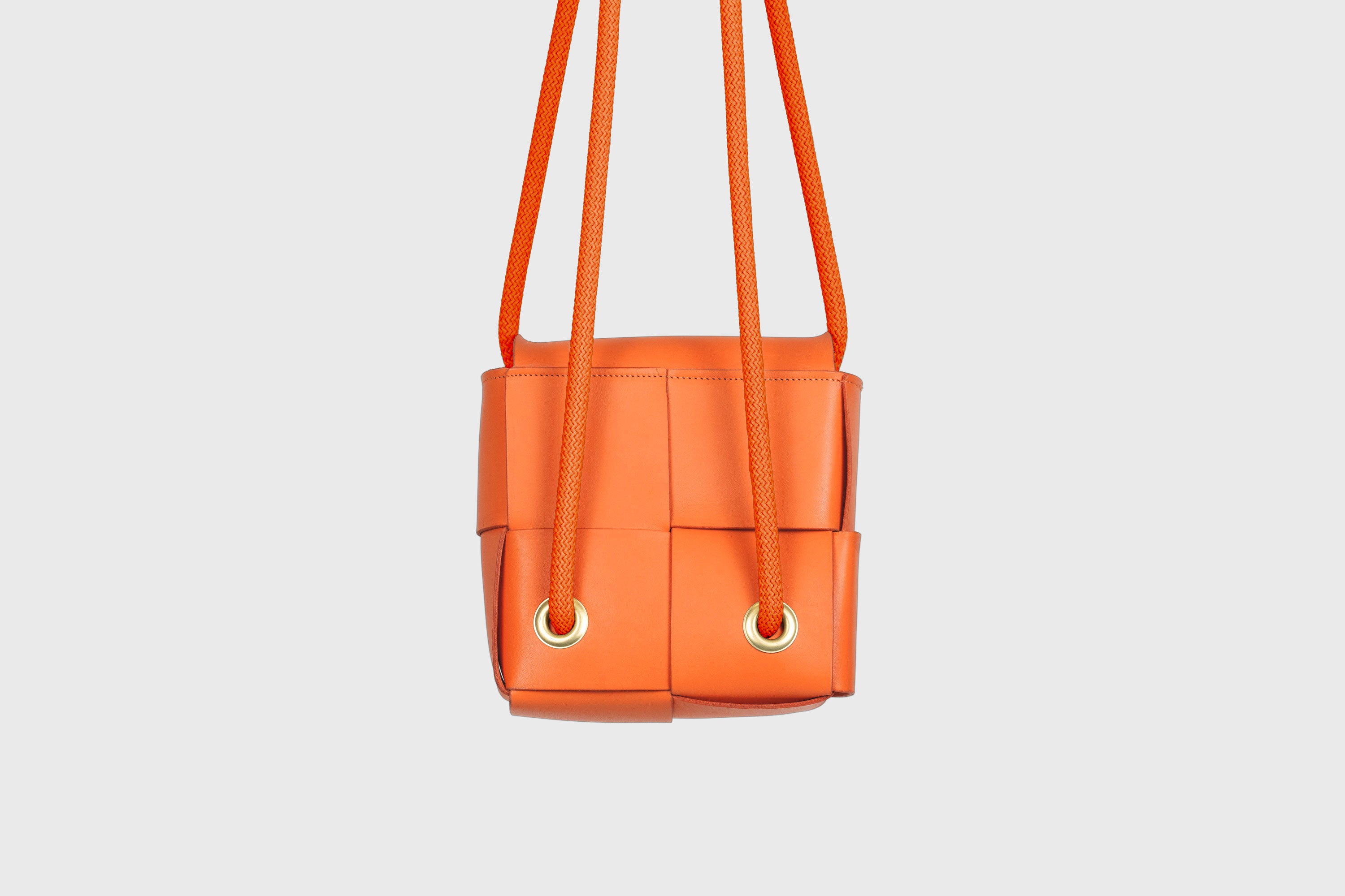 Elegant Atelier Madre Orange Color woven leather backpack, designed by Manuel Dreesmann, showcasing exquisite craftsmanship and luxury style, crafted in the heart of Barcelona.