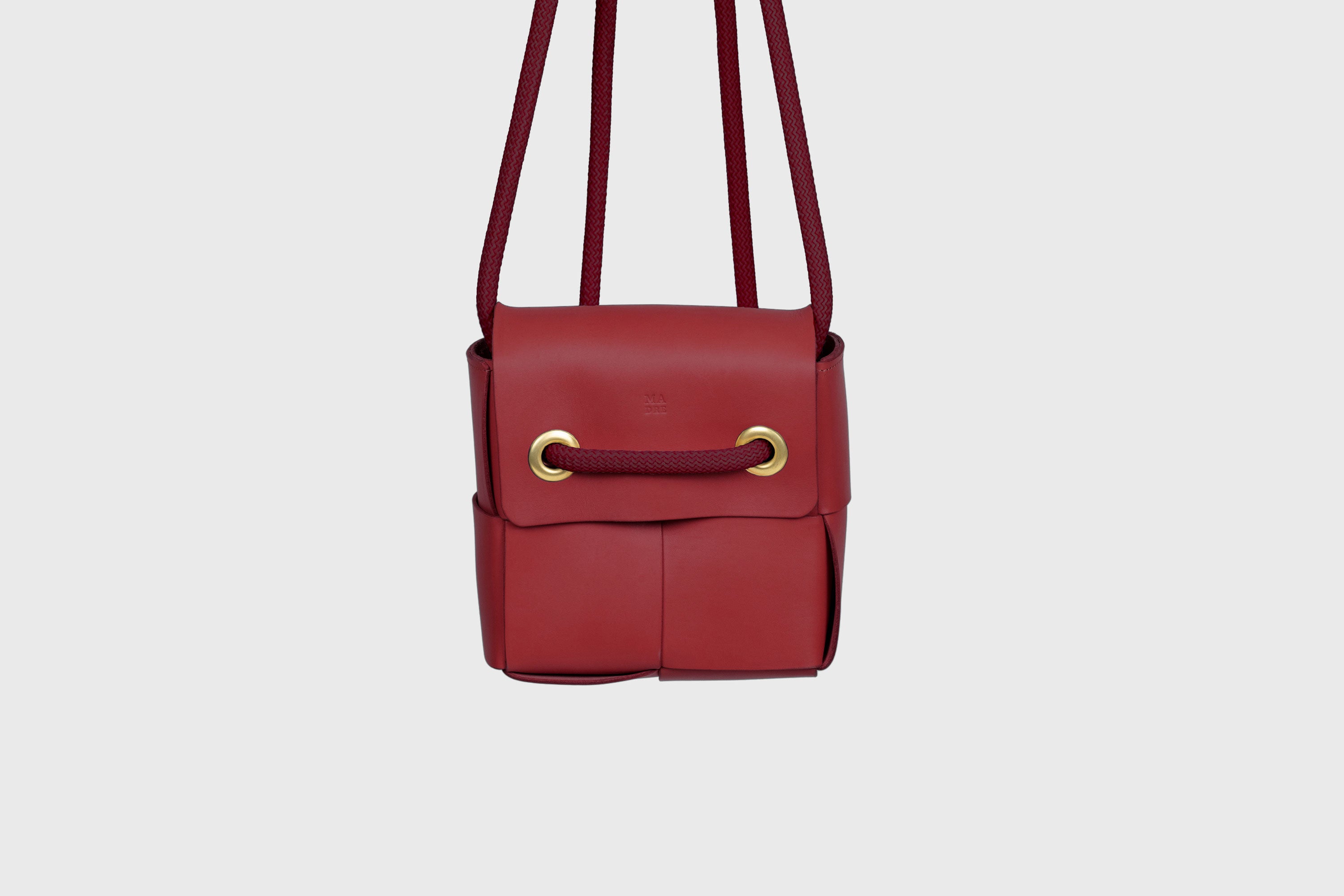 Elegant Atelier Madre Red Color woven leather backpack, designed by Manuel Dreesmann, showcasing exquisite craftsmanship and luxury style, crafted in the heart of Barcelona.