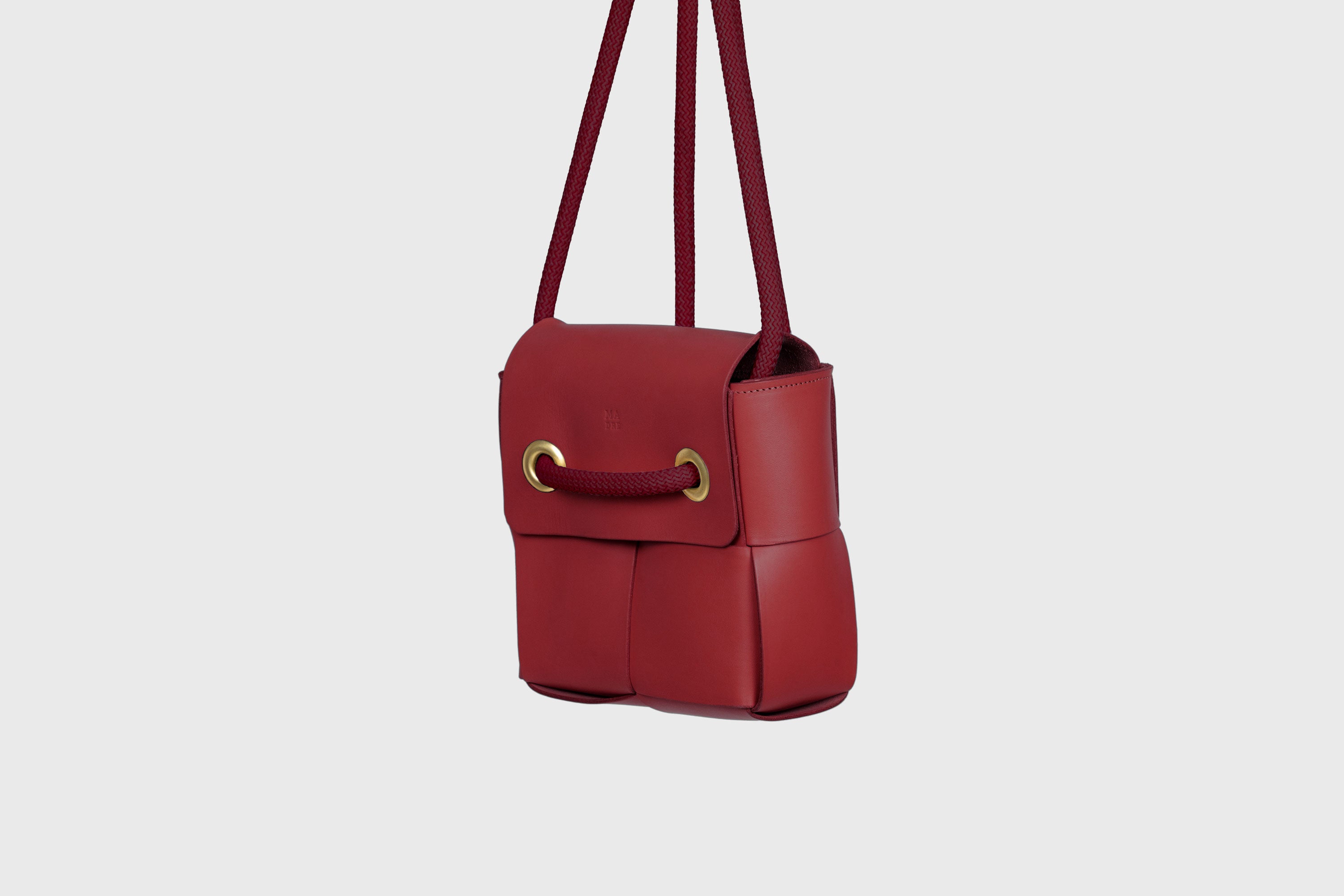 Elegant Atelier Madre Red Color woven leather backpack, designed by Manuel Dreesmann, showcasing exquisite craftsmanship and luxury style, crafted in the heart of Barcelona.
