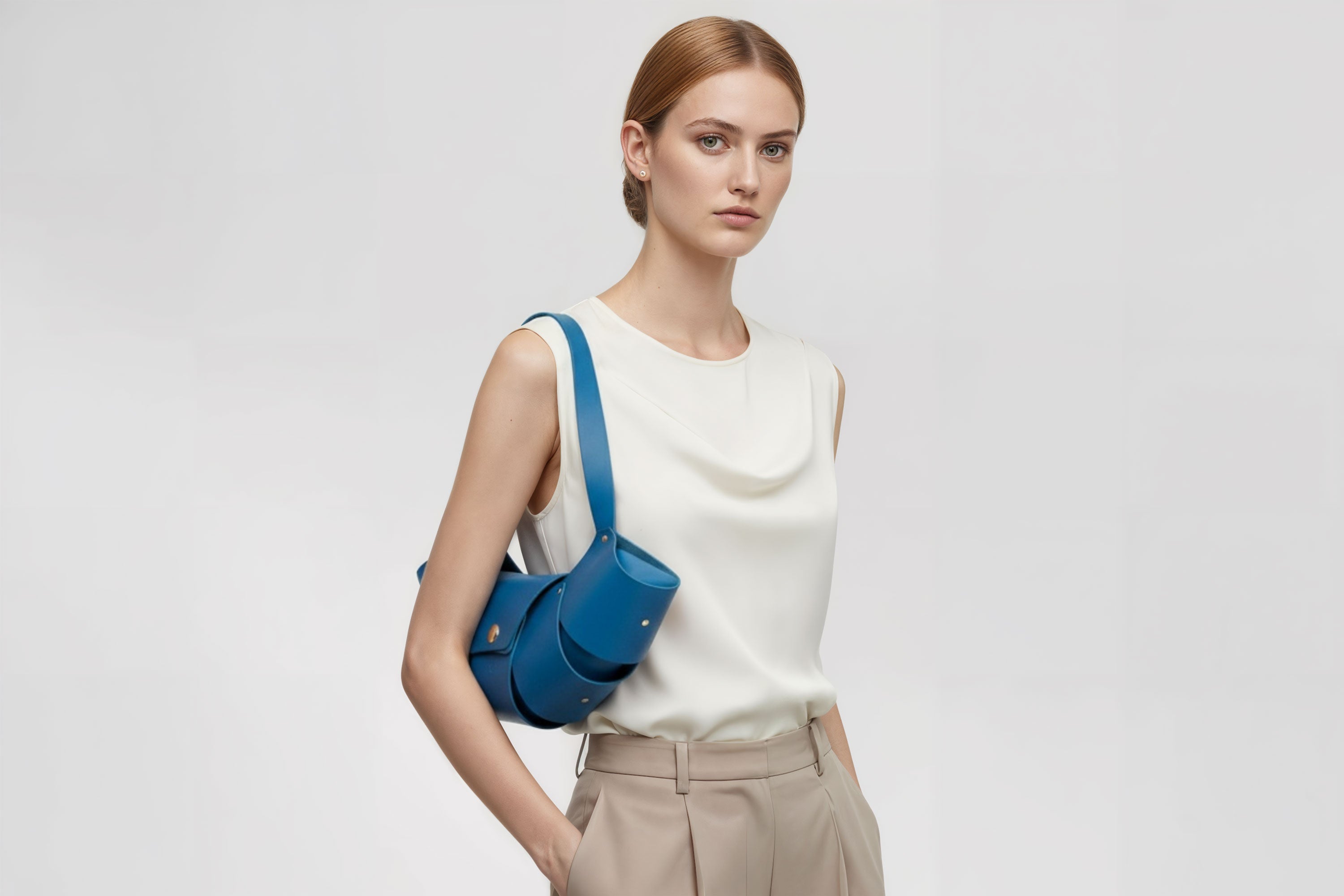 Croissant Bag Big Royal Blue Colour Leather Magnetic Closure On A Woman Model Full Grain Vegetable Tanned Leather High Quality Modern Minimalistic Organic Design Full Brass Rivets Atelier Madre Manuel Dreesmann Barcelona Spain