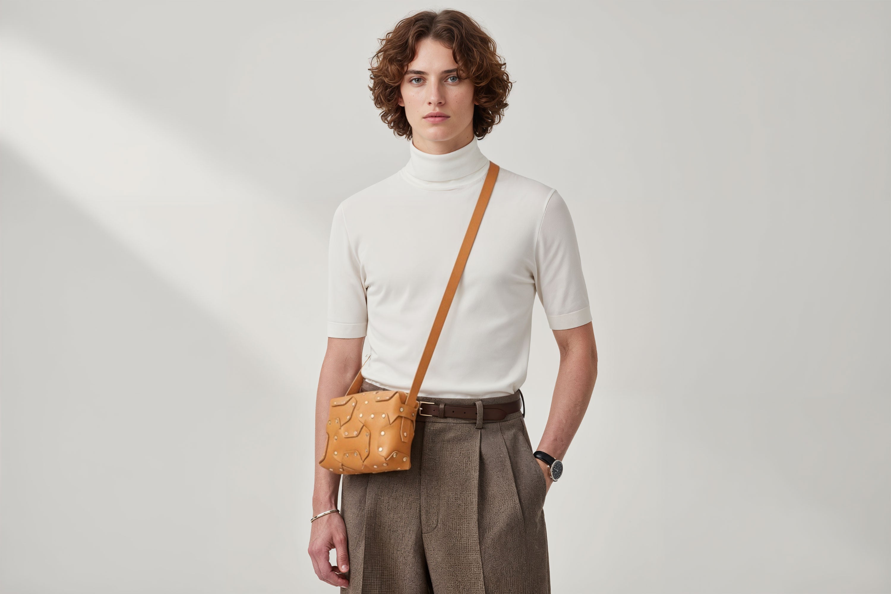Double Rivet Bag Brown Color On A Man Model Leather Full Grain Vegetable Tanned Leather Modern Minimalist Design Premium Quality Full Brass Clutch Crossbody Shoulder Bag Atelier Madre Manuel Dreesmann Barcelona Spain